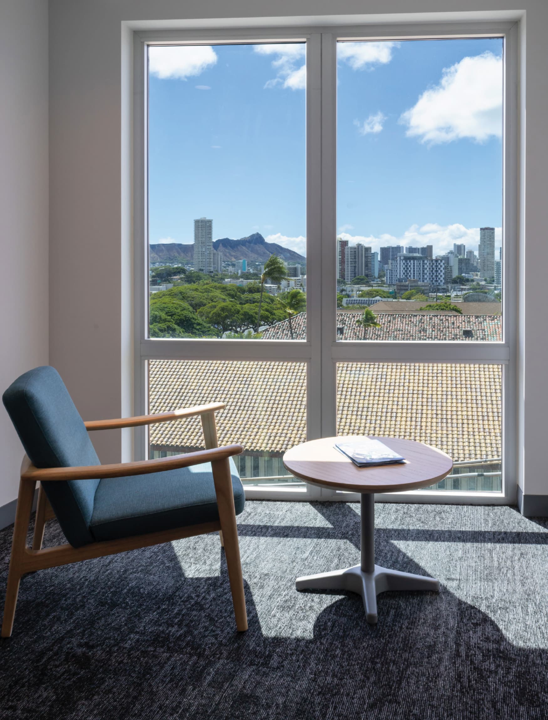 Image of the furniture and window looking over the Oahu skyline at Atherton Rise. 