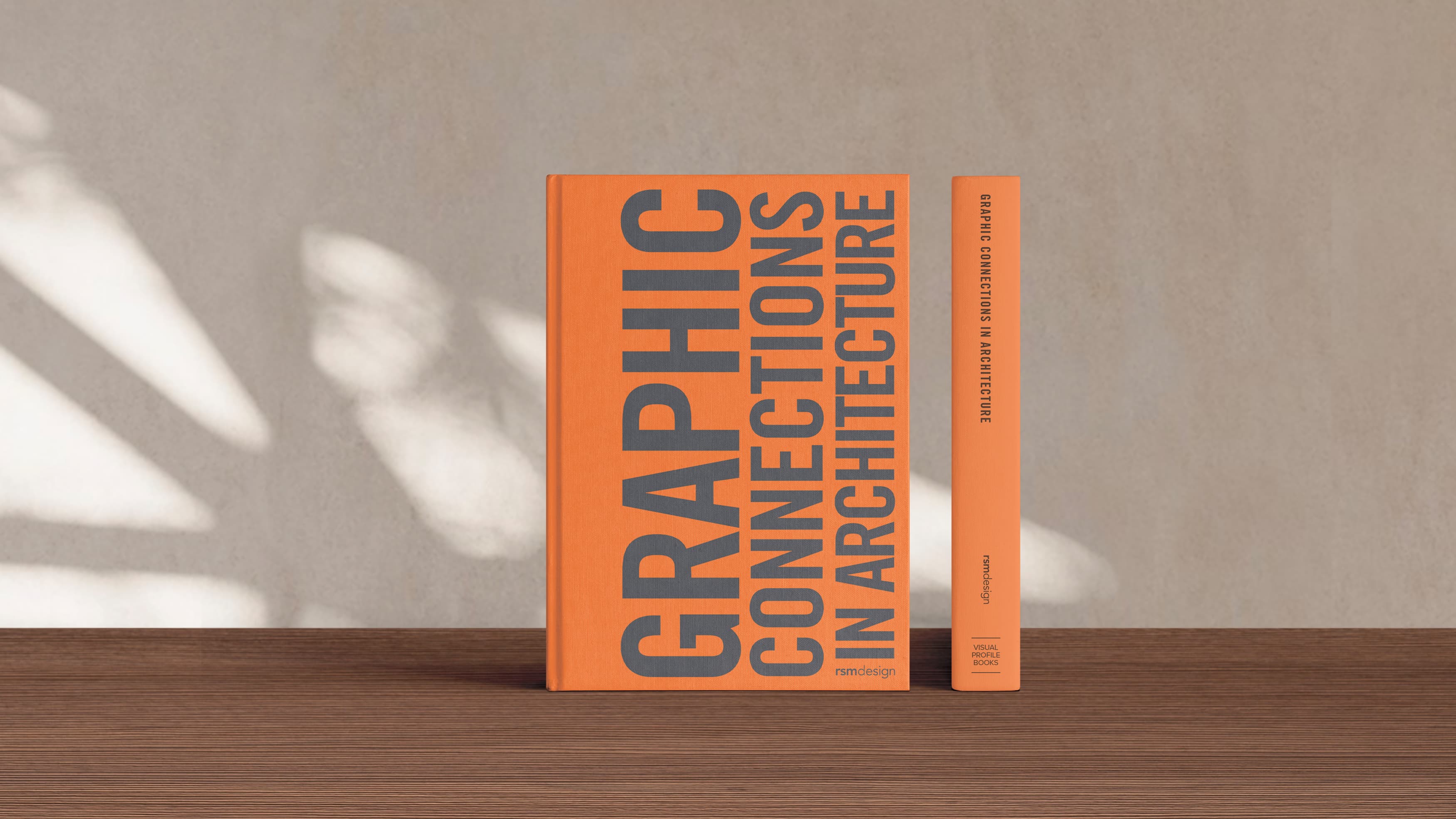 RSM Design's newest book, Graphic Connections in Architecture, sits on a hardwood table.
