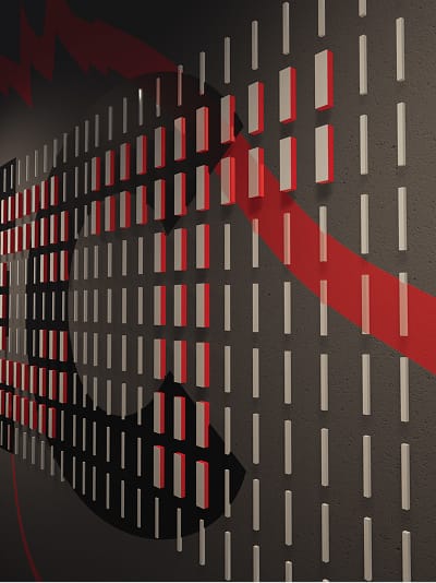 Close-up detail of a dimensional wall installation featuring a grid of small rectangular panels in white, red, and dark tones mounted on a dark gray surface. A bold red sweeping graphic element cuts diagonally across the panels, casting shadows and creating depth. The composition forms part of a larger typographic or abstract design.
