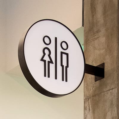 Restroom wayfinding signage at Runway Playa Vista retail district in Los Angeles, designed as part of the environmental graphics and signage program by RSM Design.