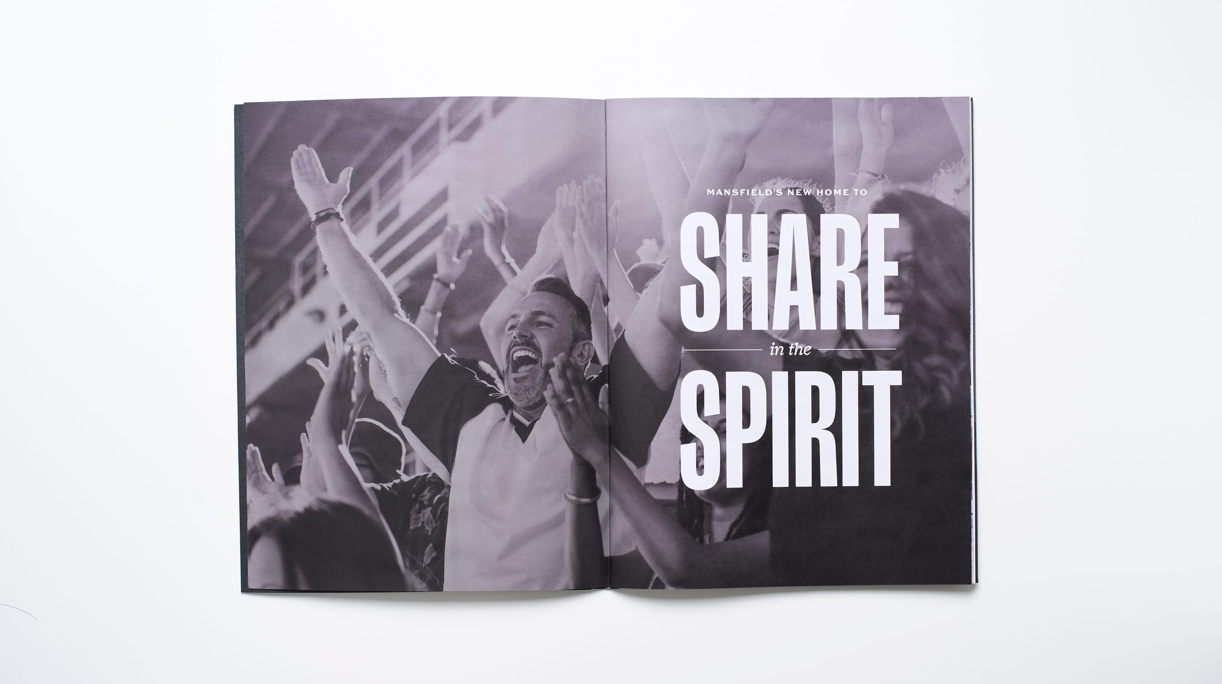 Open leasing brochure spread with a black and white photo of a cheering stadium crowd with raised hands, paired with the headline Mansfield's New Home to Share in the Spirit, Staybolt Street, Mansfield, Texas, brand identity and leasing collateral design by RSM Design