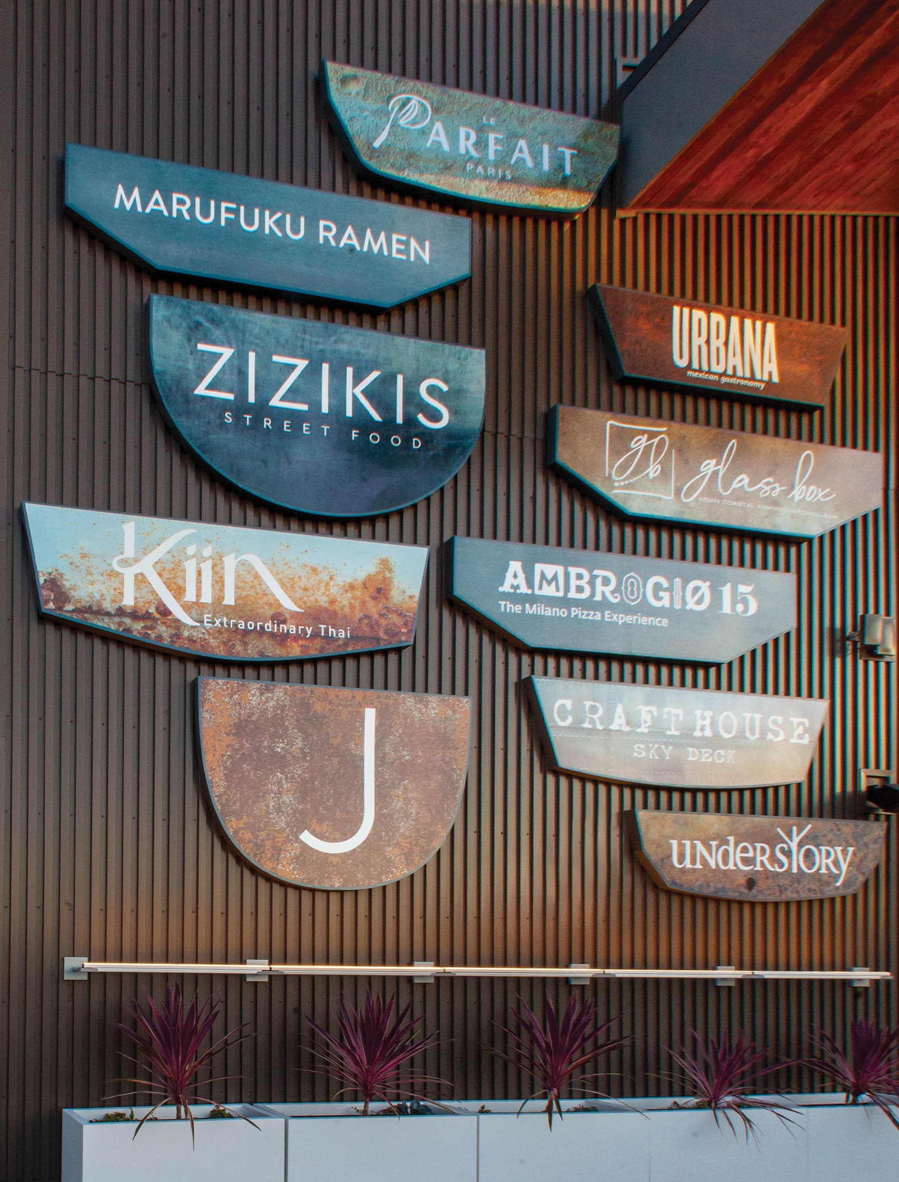 Mounted plaque tenant directory wall signage for The Skydeck, a retail food and beverage hall, located in Del Mar, California.