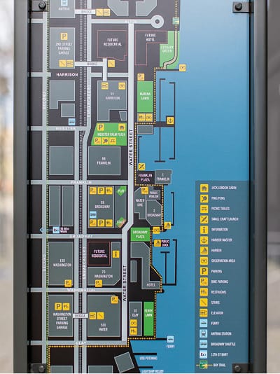 Jack London Square outdoor wayfinding map and directory sign showing marina, waterfront plazas, parking, ferry terminal, and nearby streets including Water Street and Harrison Street in Oakland, California
