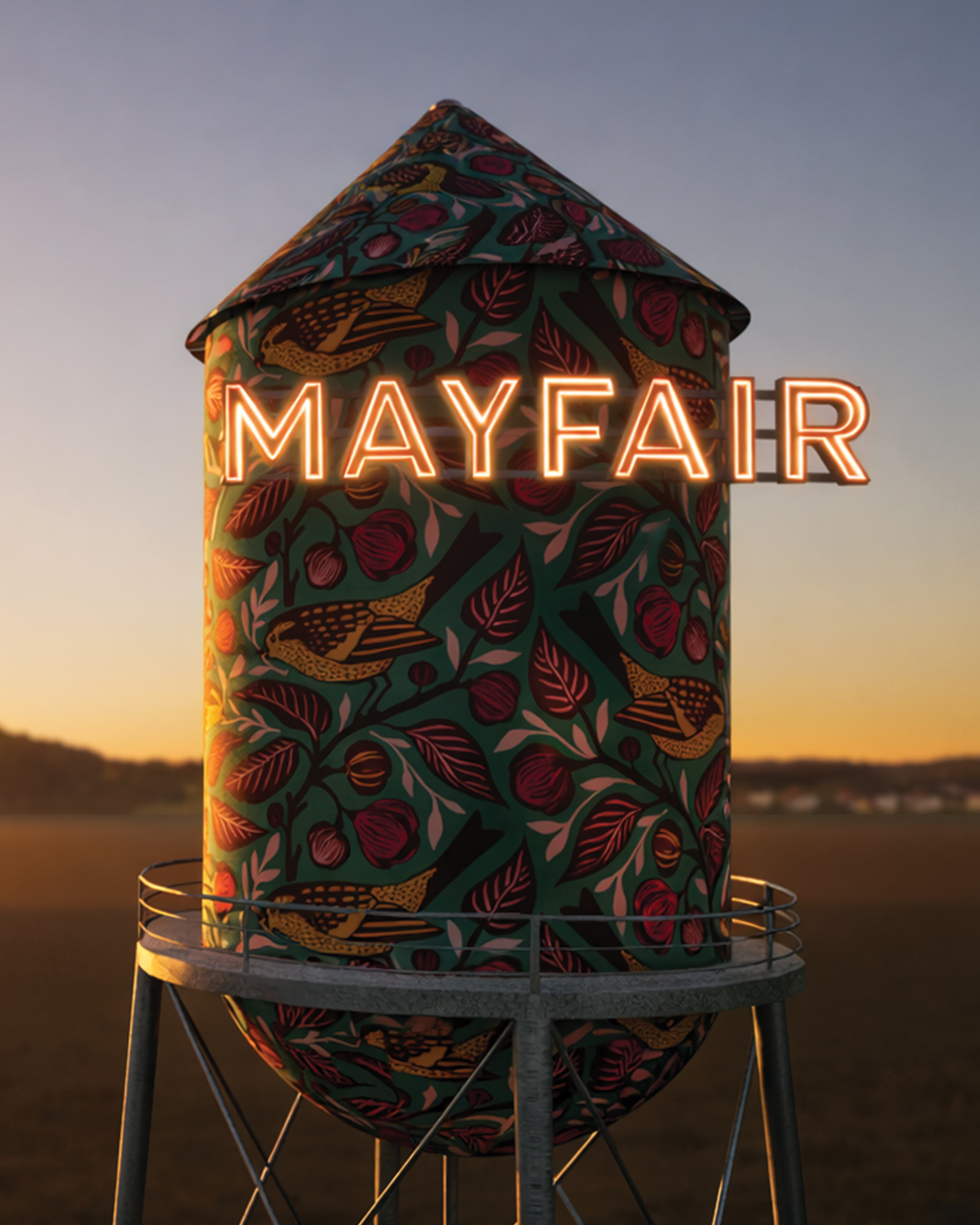 Architectural rendering of a decorative water tower wrapped in a colorful botanical and bird mural pattern with illuminated "Mayfair" neon signage at sunset, showcasing art programs, experiential graphics, and placemaking design for a mixed-use residential community by RSM Design.