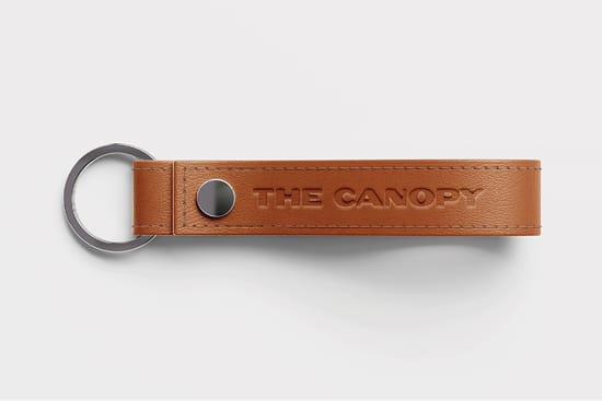 Leather keychain embossed with The Canopy logo - branded merchandise design by RSM Design