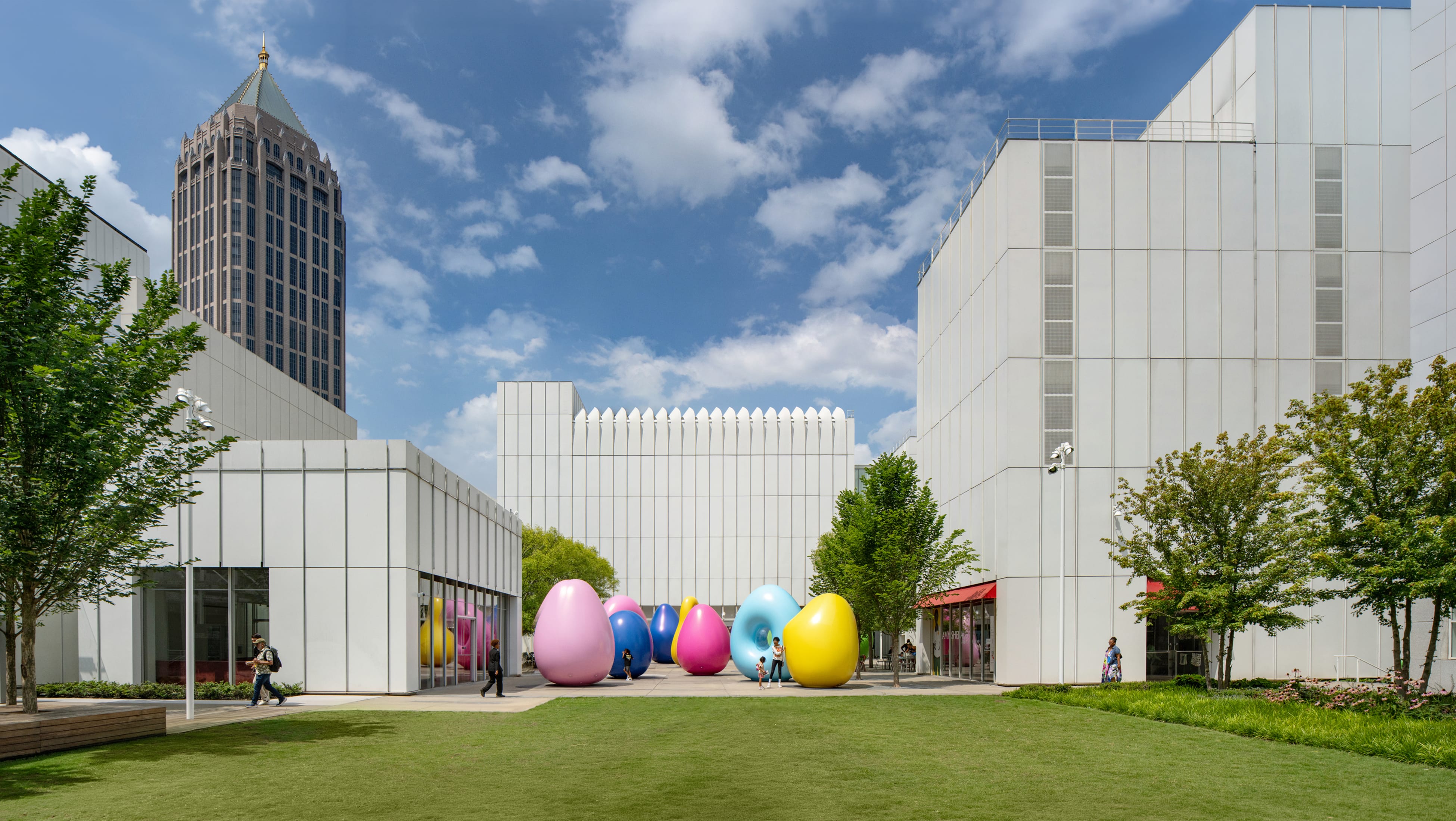 Woodruff Arts Center campus in Midtown Atlanta with white architecture by Richard Meier and Renzo Piano, a green lawn, and a colorful outdoor sculpture installation near the High Museum of Art – campus wayfinding and environmental graphic design by RSM Design.