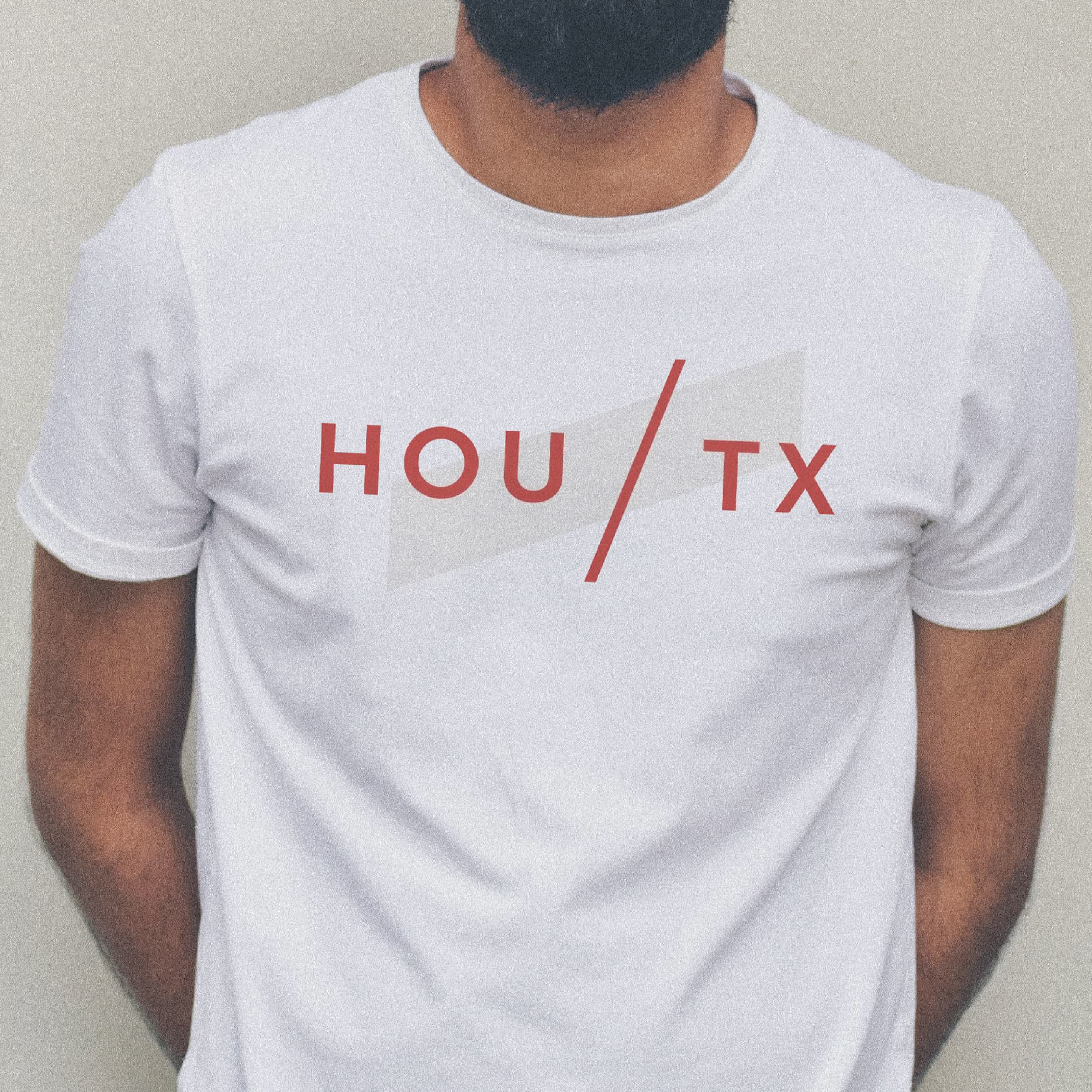 White branded T-shirt featuring HOU/TX graphic for The Bend Houston, highlighting brand identity design, graphic design, and experiential branding that support placemaking for a mixed-use retail, dining, and entertainment destination.