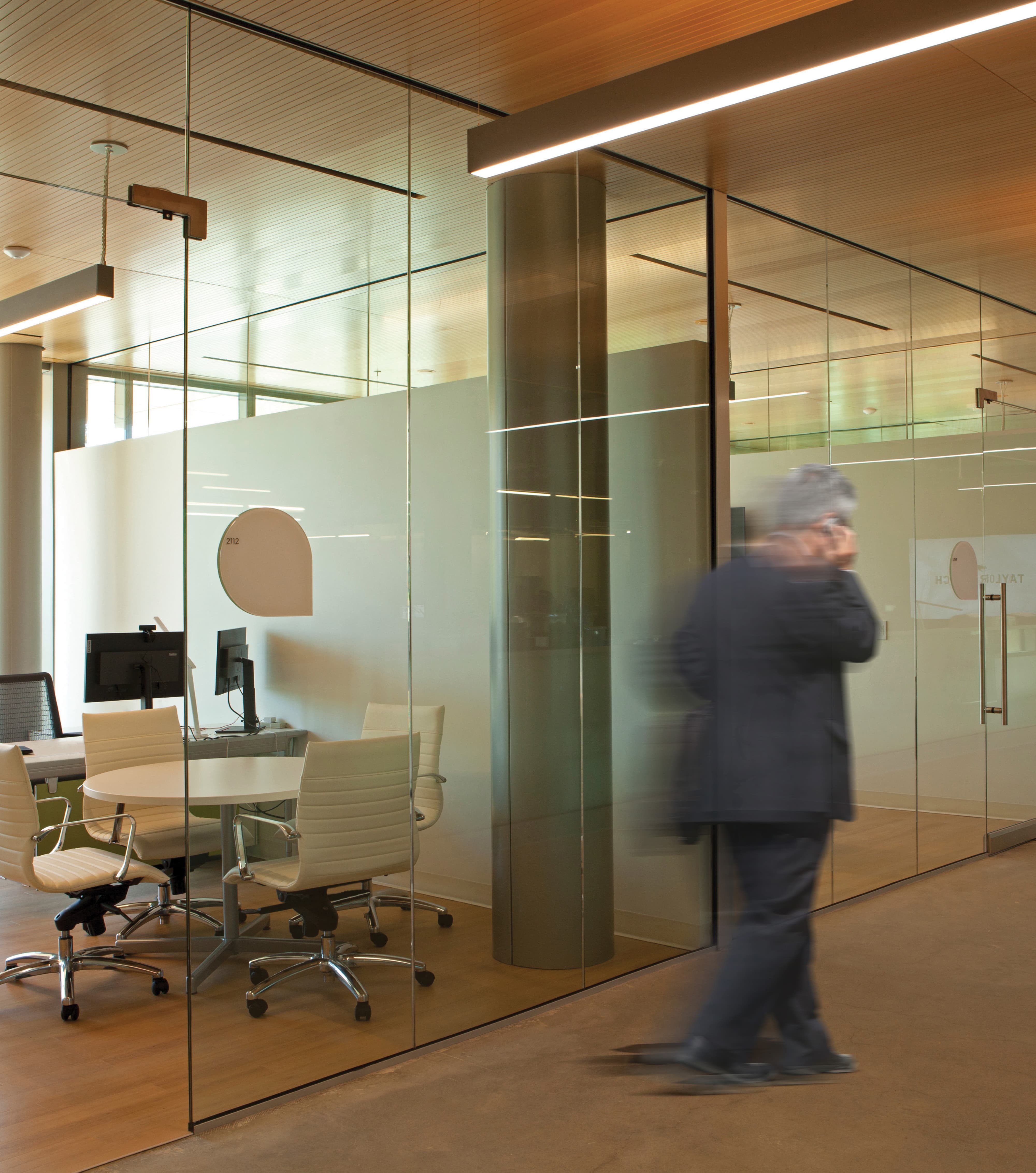 Modern workplace interior with glass-walled meeting rooms, integrated environmental graphic design, and subtle wayfinding and branded elements, illustrating RSM Design expertise in experiential design, workplace environments, and corporate placemaking through identity-driven spatial design.