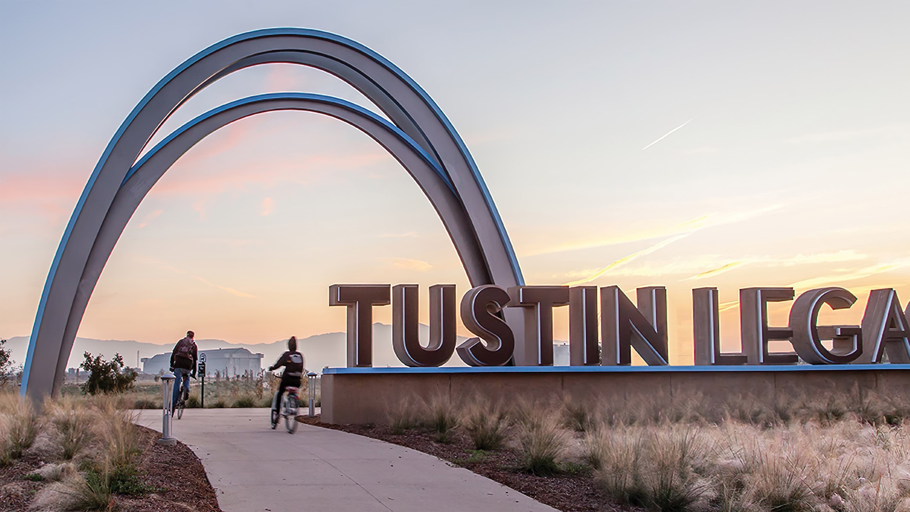 A photograph of a monument sign at Tustin Legacy featuring an arch and large fabricated letters.