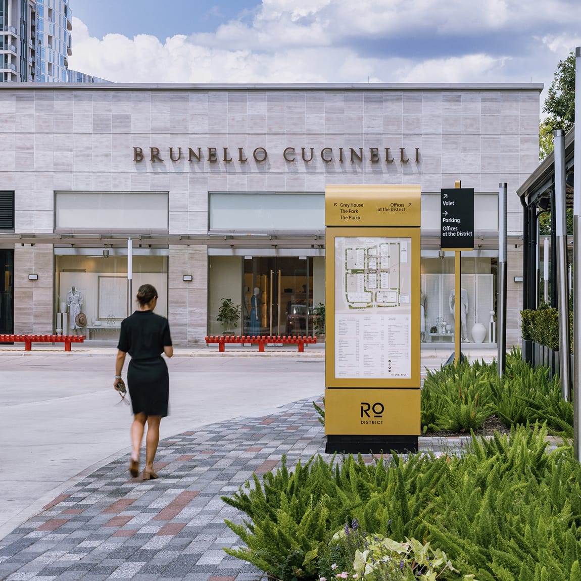 River Oaks District Houston gold directory kiosk with directional signage near Brunello Cucinelli storefront, wayfinding design by RSM Design