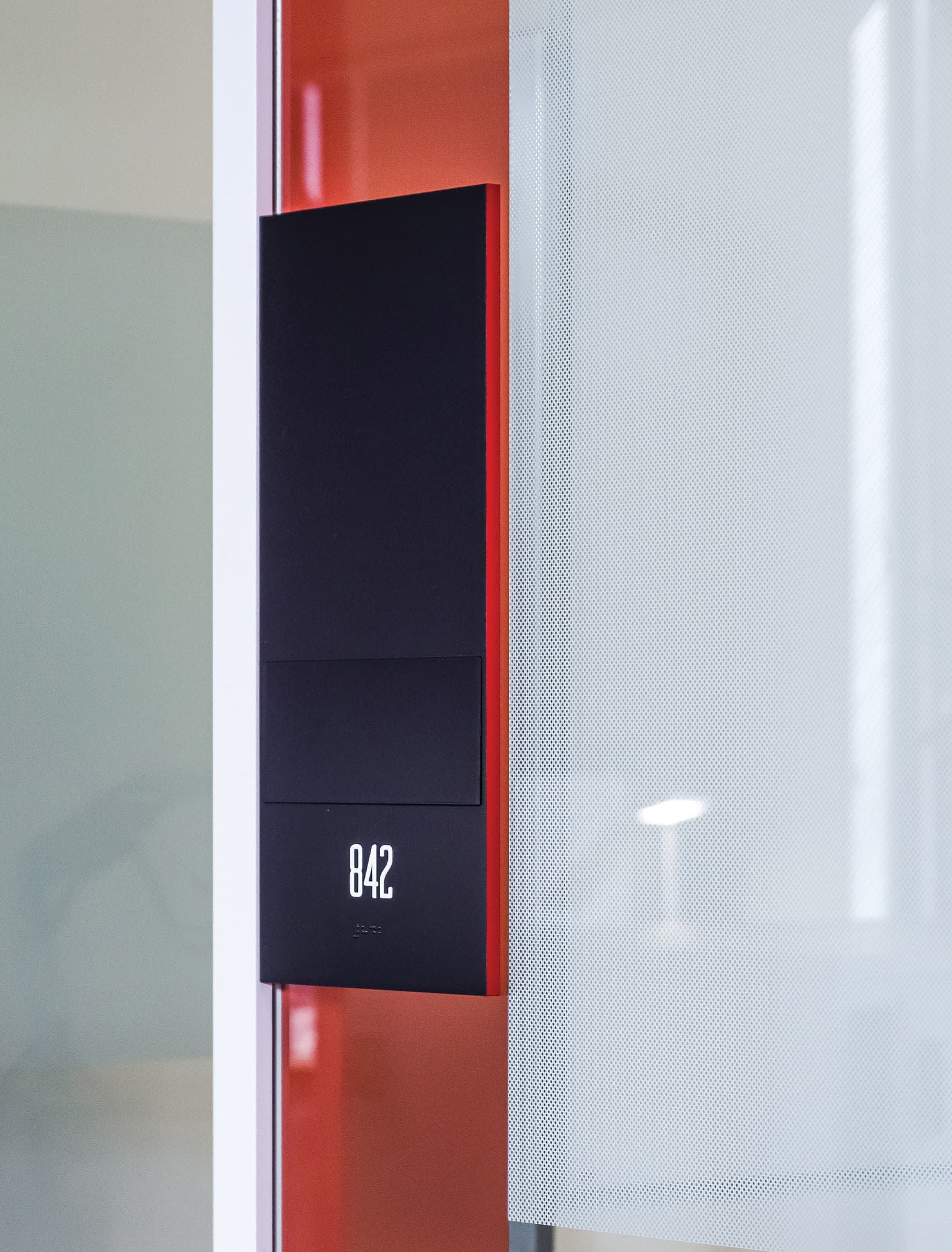 Doorway vertical signage for Chemonics International by RSM Design. Red and black signage.