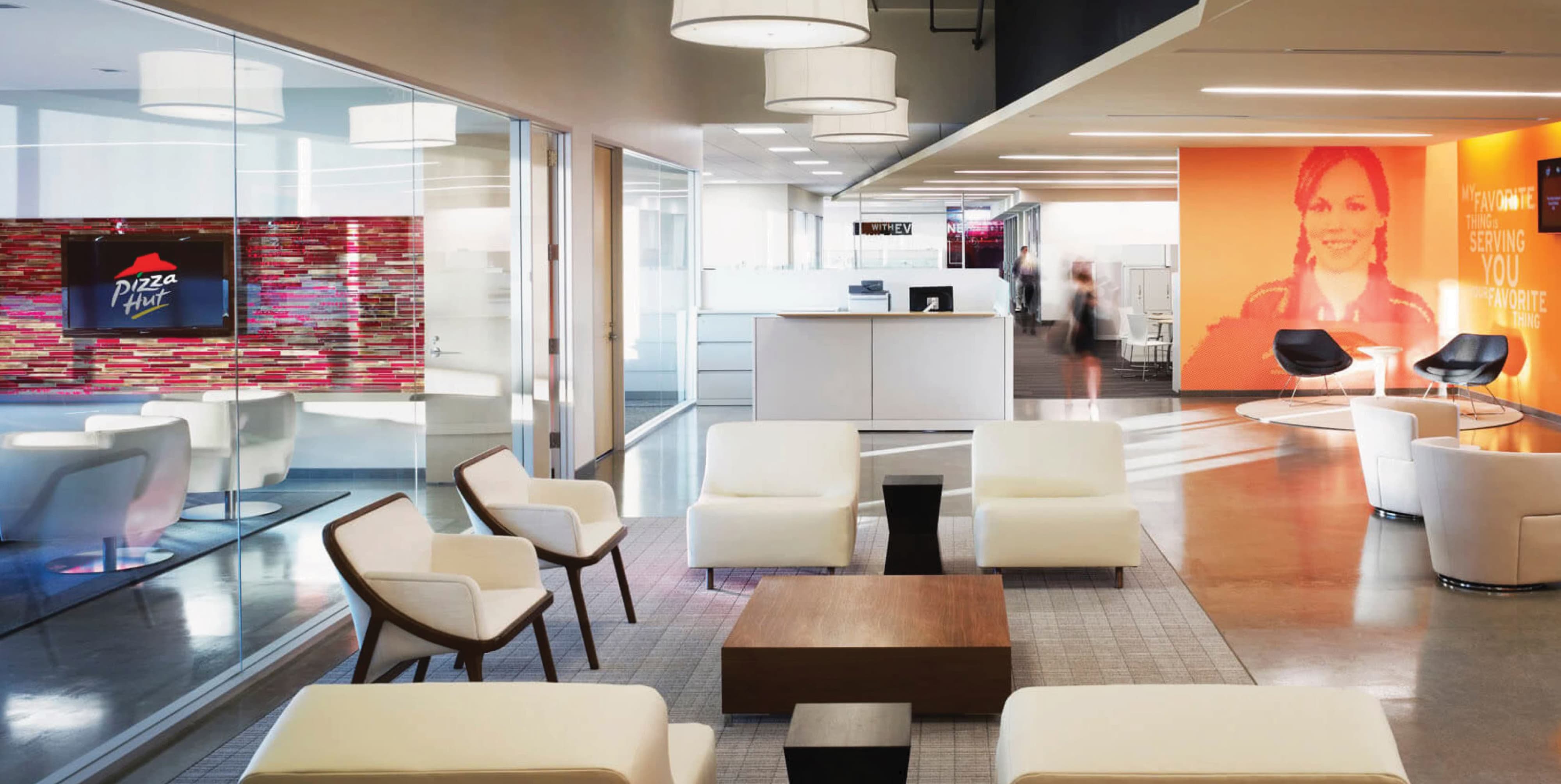 Corporate workplace interior featuring branded environmental graphics, large-scale graphic wall installations, and experiential design elements that communicate brand identity and storytelling within a modern office and workplace environment.