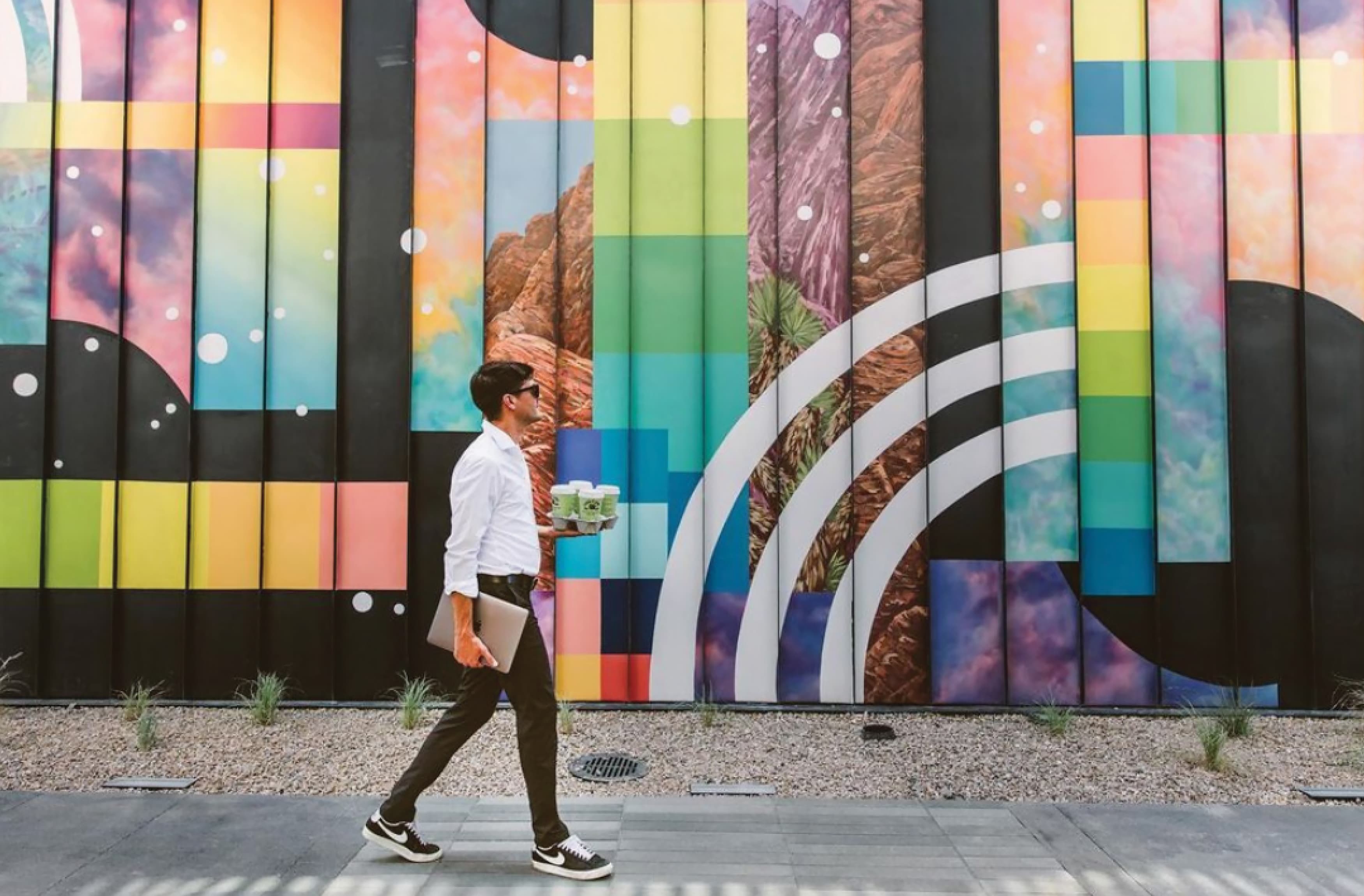 Image of man walking past the murals at UnCommons in Las Vegas, Nevada.