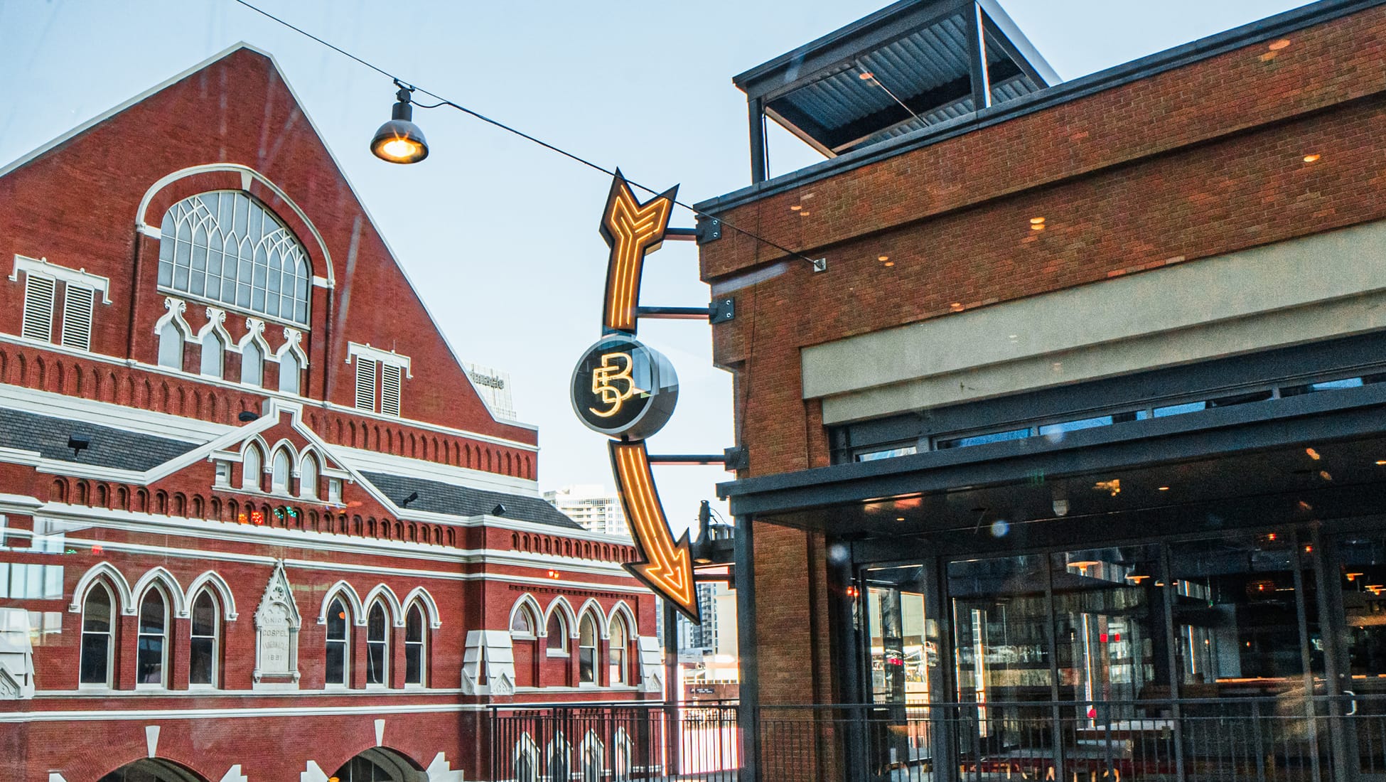 A contemporary blade sign draws from historic architectural cues, using light and form to create a bold marker that connects past and present within the streetscape.