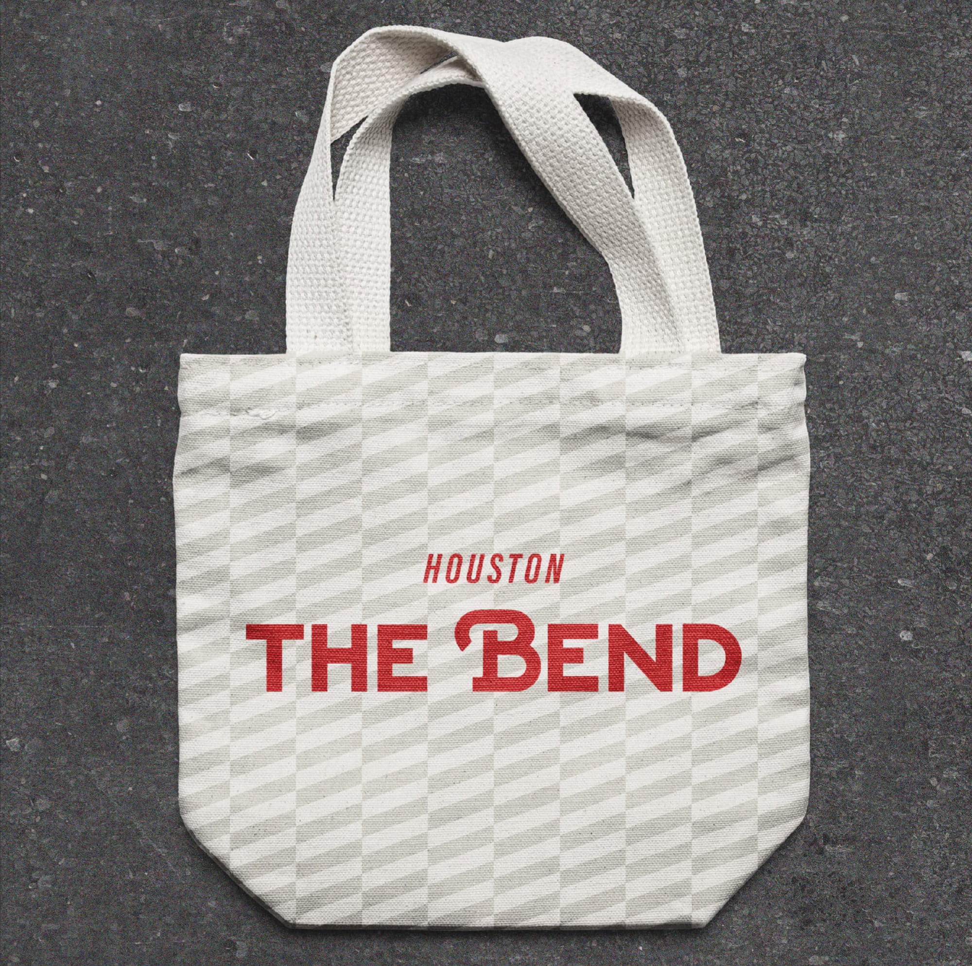 Branded tote bag featuring The Bend Houston logo and graphic pattern, highlighting brand identity design, graphic design, and experiential branding that support placemaking for a mixed-use retail, dining, and entertainment destination.