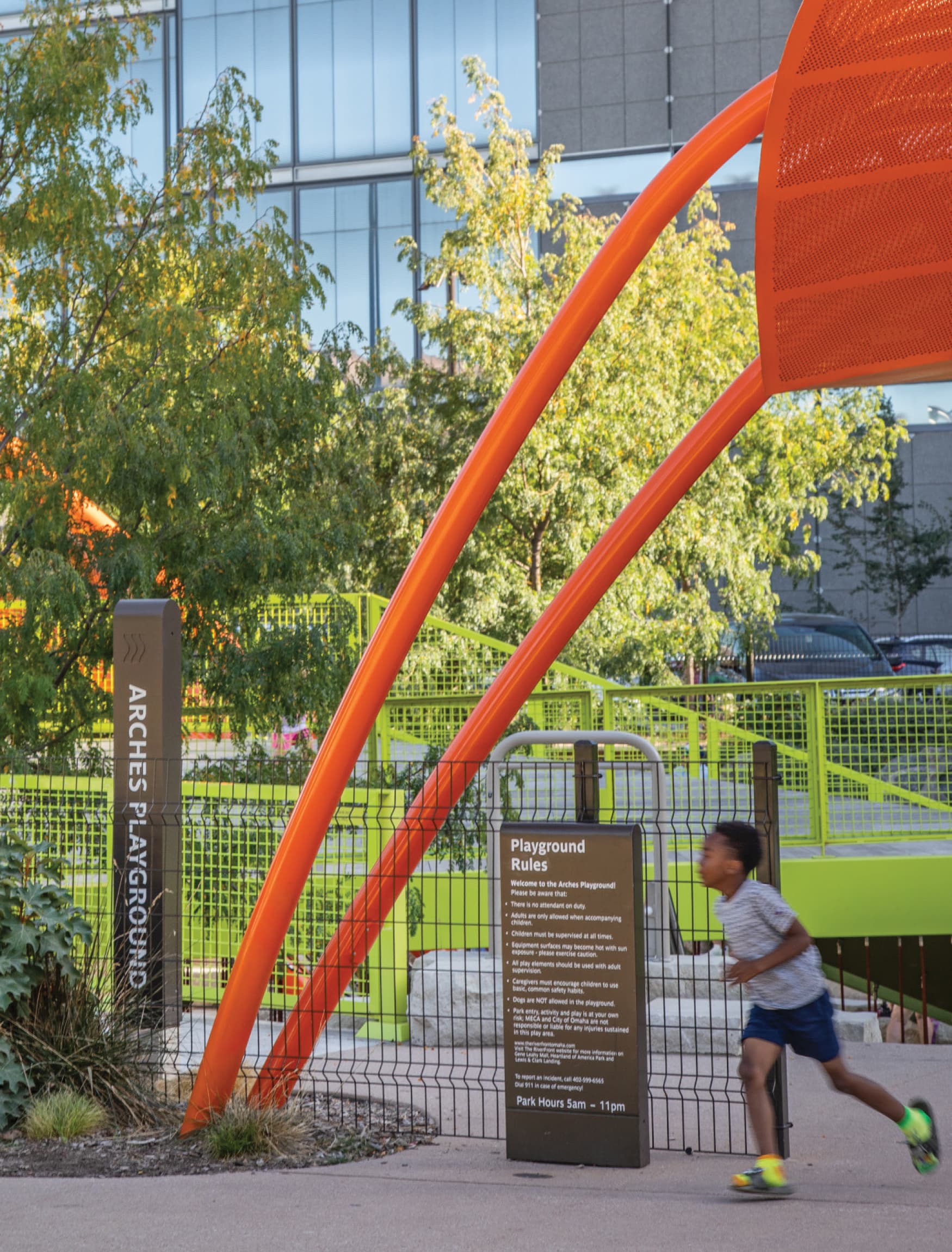 Image of a boy running by the playground at the Omaha Riverfront Park. Arches Playground at Omaha RiverFront park. 