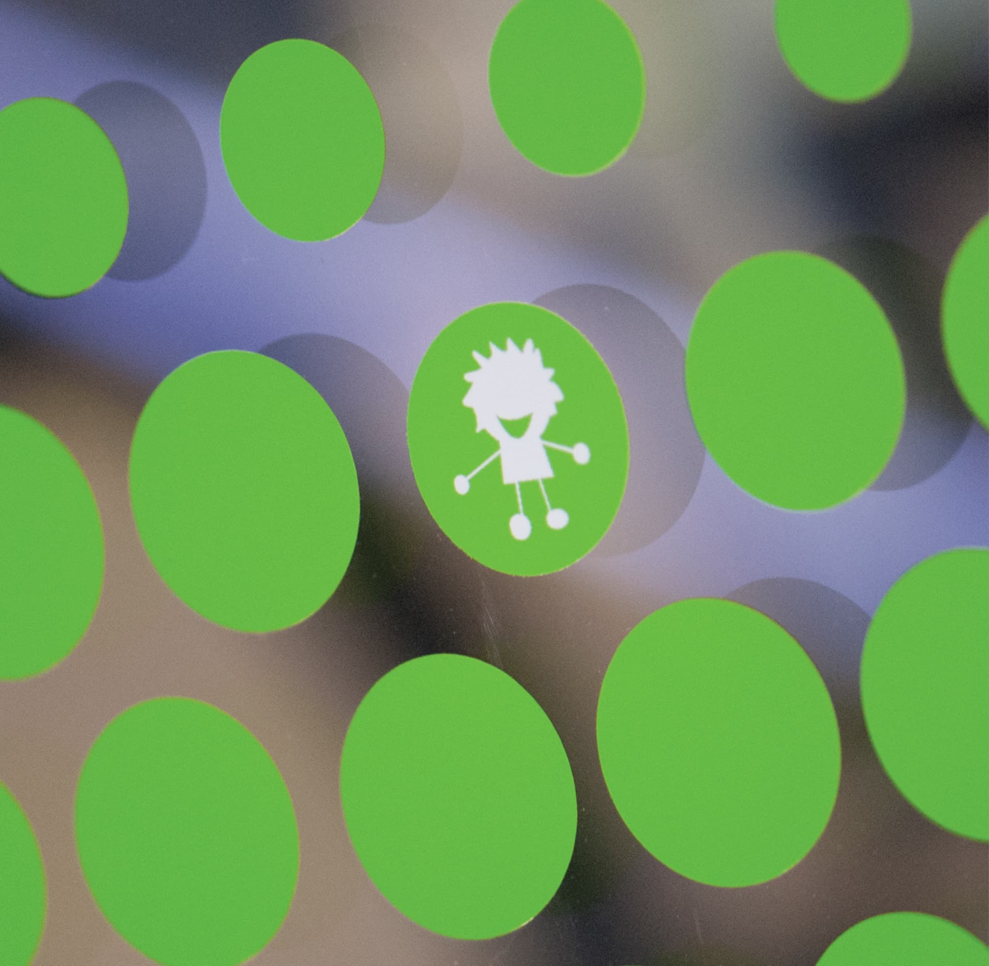 Close-up detail of a playful green polka dot pattern glass graphic with a hidden white child figure illustration on a frosted glazing panel at University of the Pacific San Francisco Campus pediatric dental clinic — RSM Design specialty graphics, experiential graphics, branded environments, and placemaking for education and health and wellness destinations.
