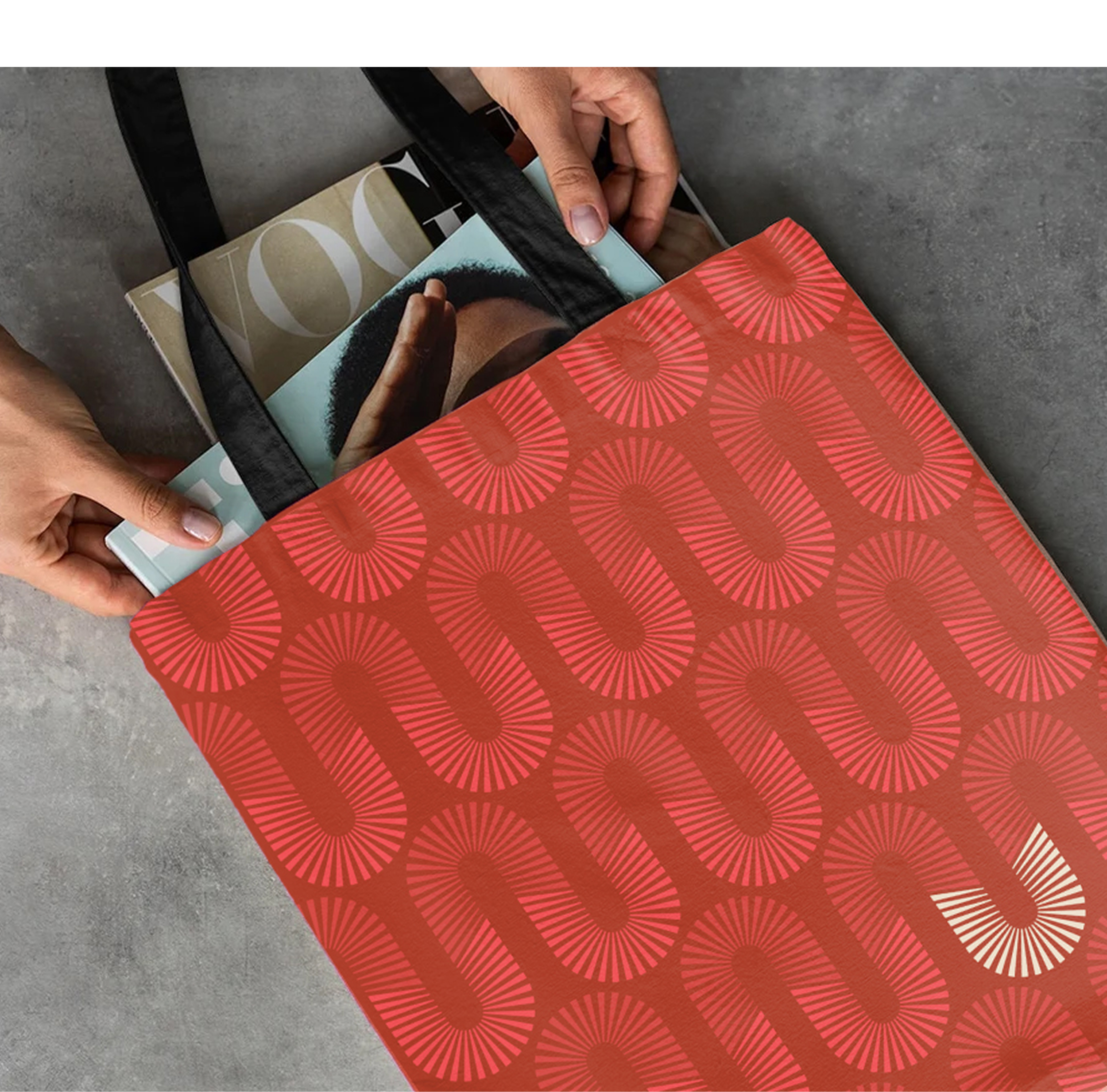 Uptown Tucson tote bag with repeating U emblem pattern in red, holding magazines, brand pattern design by RSM Design