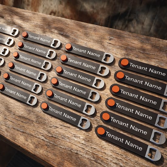 Custom tenant directory nameplates with industrial-inspired design, featuring metal tags, engraved typography, and orange accent markers, reflecting the branded wayfinding system at San Antonio’s Pearl District.