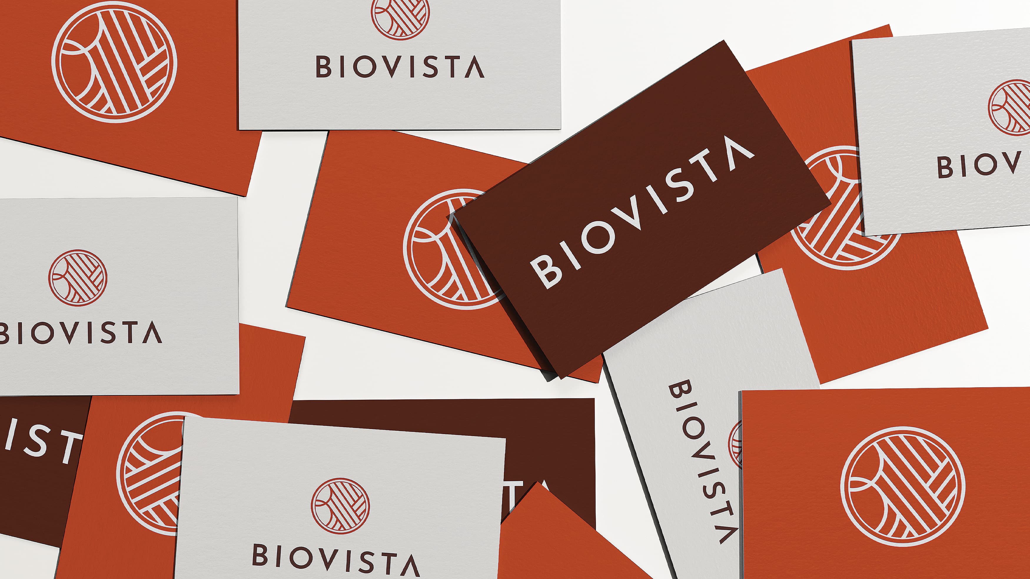Colorful orange business cards spread across a table with the Biovista logo on them.