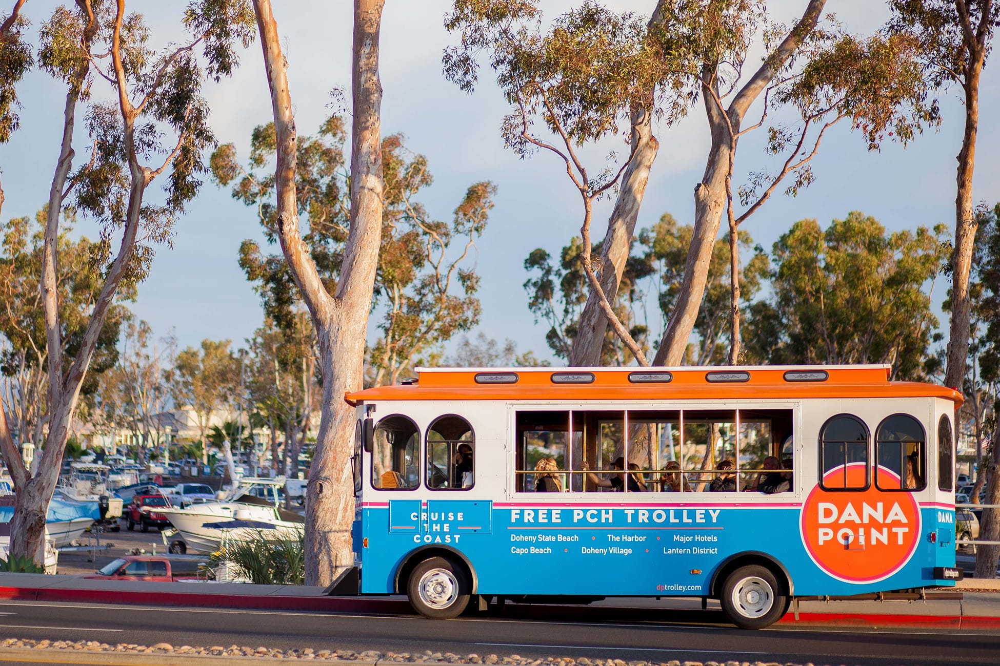 Dana Point free PCH trolley alongside harbor and eucalyptus trees, wayfinding graphics by RSM Design