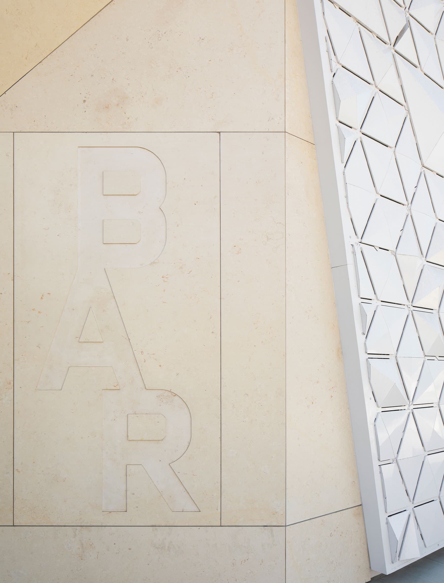 Concrete wall engraved logo signage. Exterior building identity for the BAR Center in Venice, California.