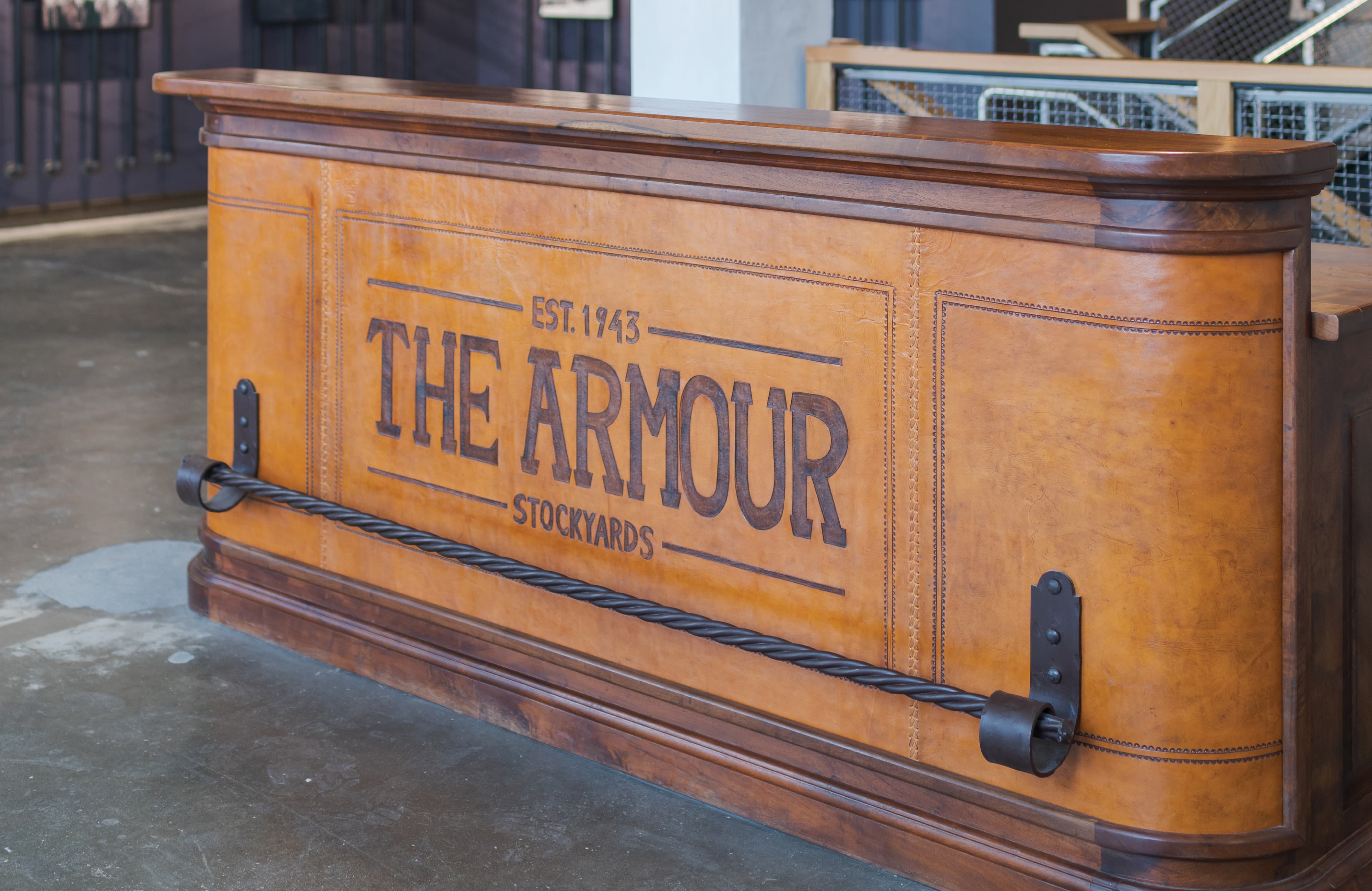 The Armour Stockyards leather-clad reception desk with branded signage, environmental graphic design by RSM Design