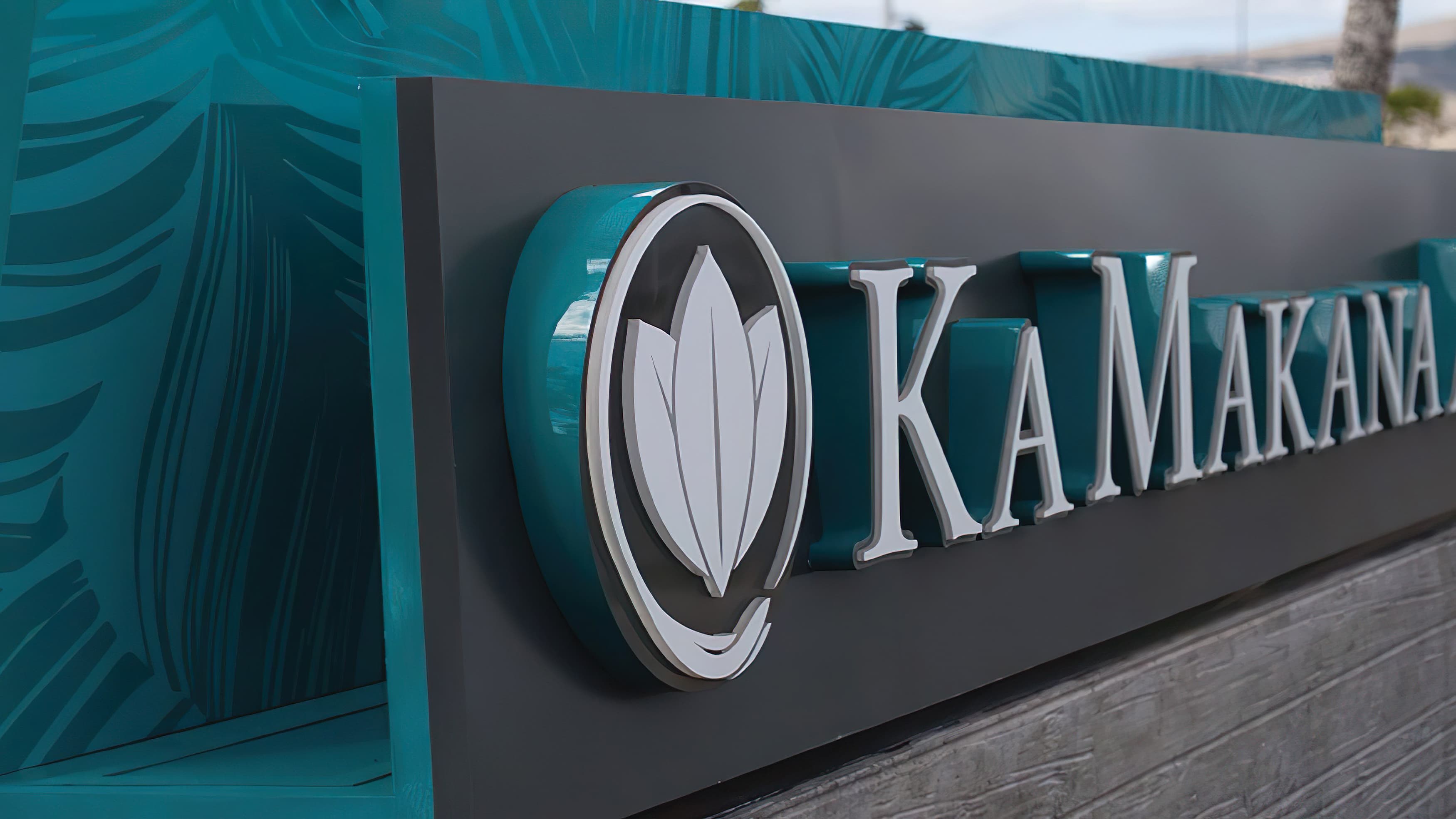 Monument signage at Ka Makana in Hawaii with tone on tone pattern and colored letter returns