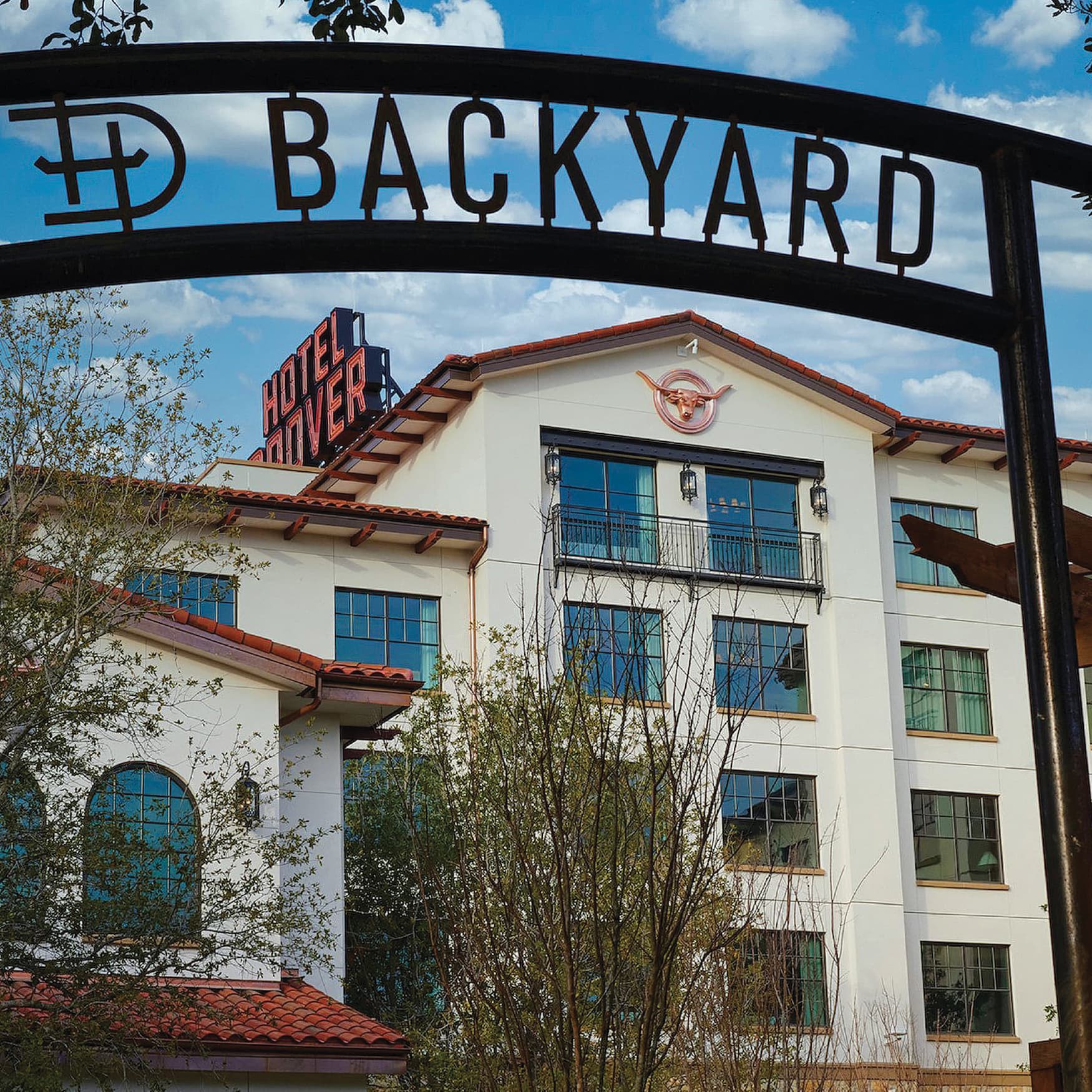 Image of the backyard entrance sign at the Hotel Drover in the back garden. Overhead signage for the Backyard at the Hotel Drover with logo mark. 