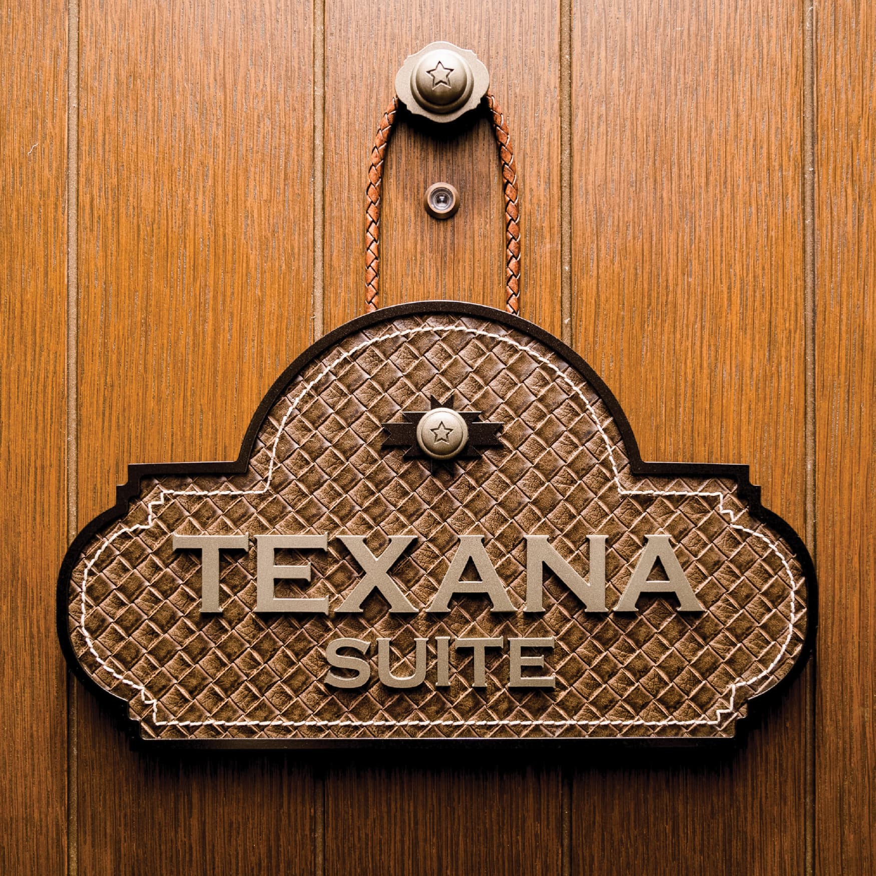 Detail image of the Texana Suite signage on woven leather designed by RSM Design for the interior of the Hotel Drover. 