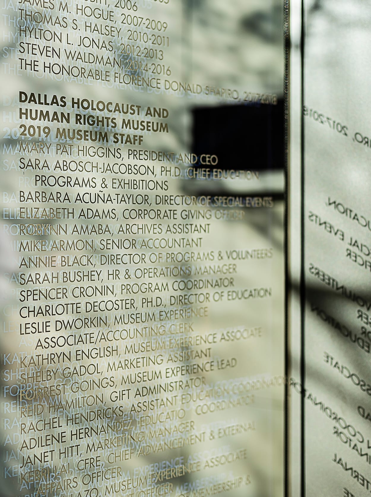 Close-up detail of etched glass staff and leadership recognition wall at Dallas Holocaust and Human Rights Museum - donor and recognition graphics by RSM Design