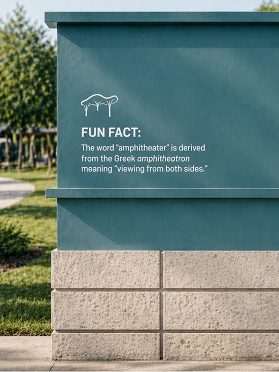 Teal interpretive sign on a stone base at Grand Park reading "Fun Fact: The word 'amphitheater' is derived from the Greek amphitheatron meaning 'viewing from both sides.'"