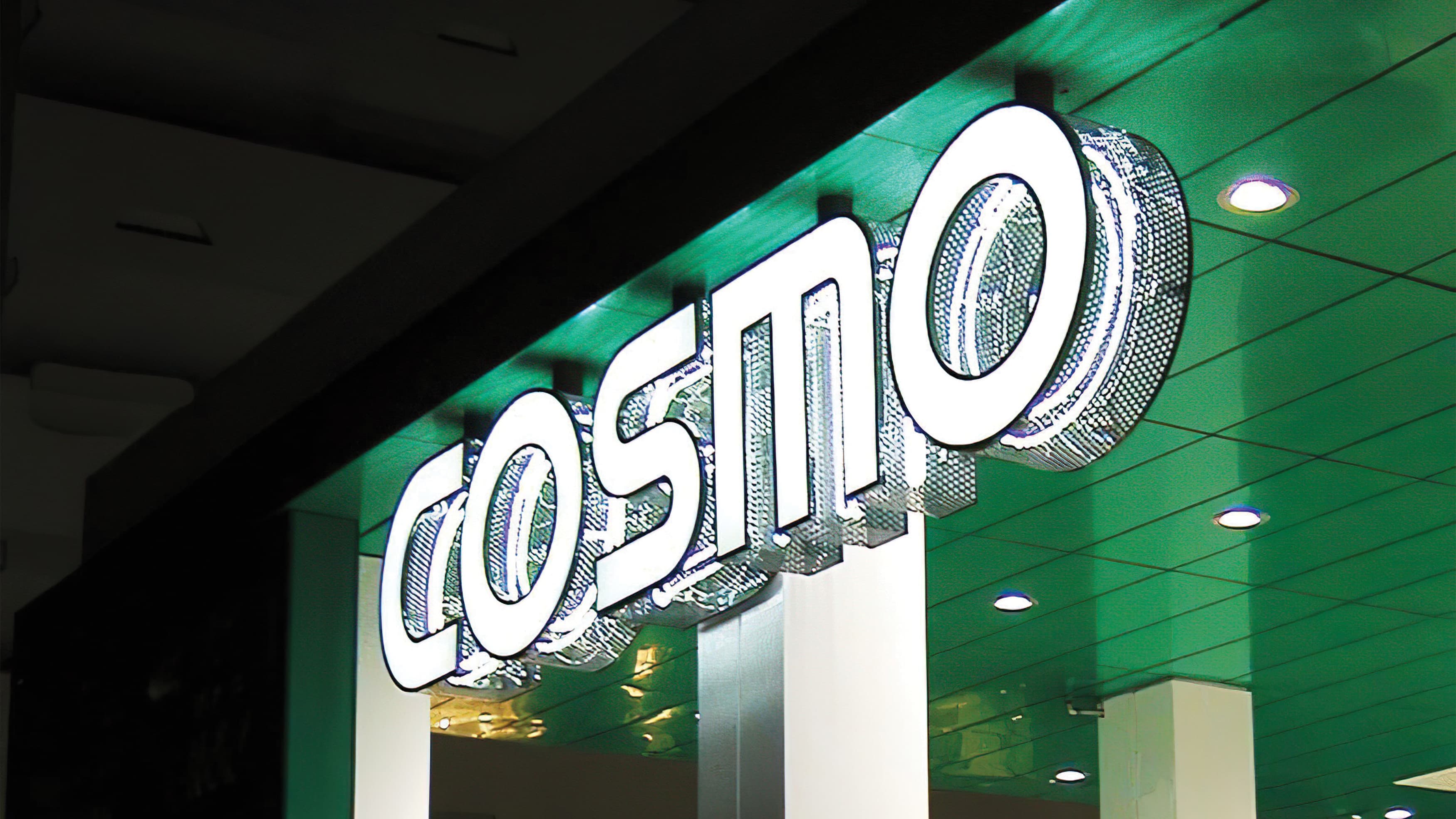 Cosmo perforated signage with internal illumination in white with green background