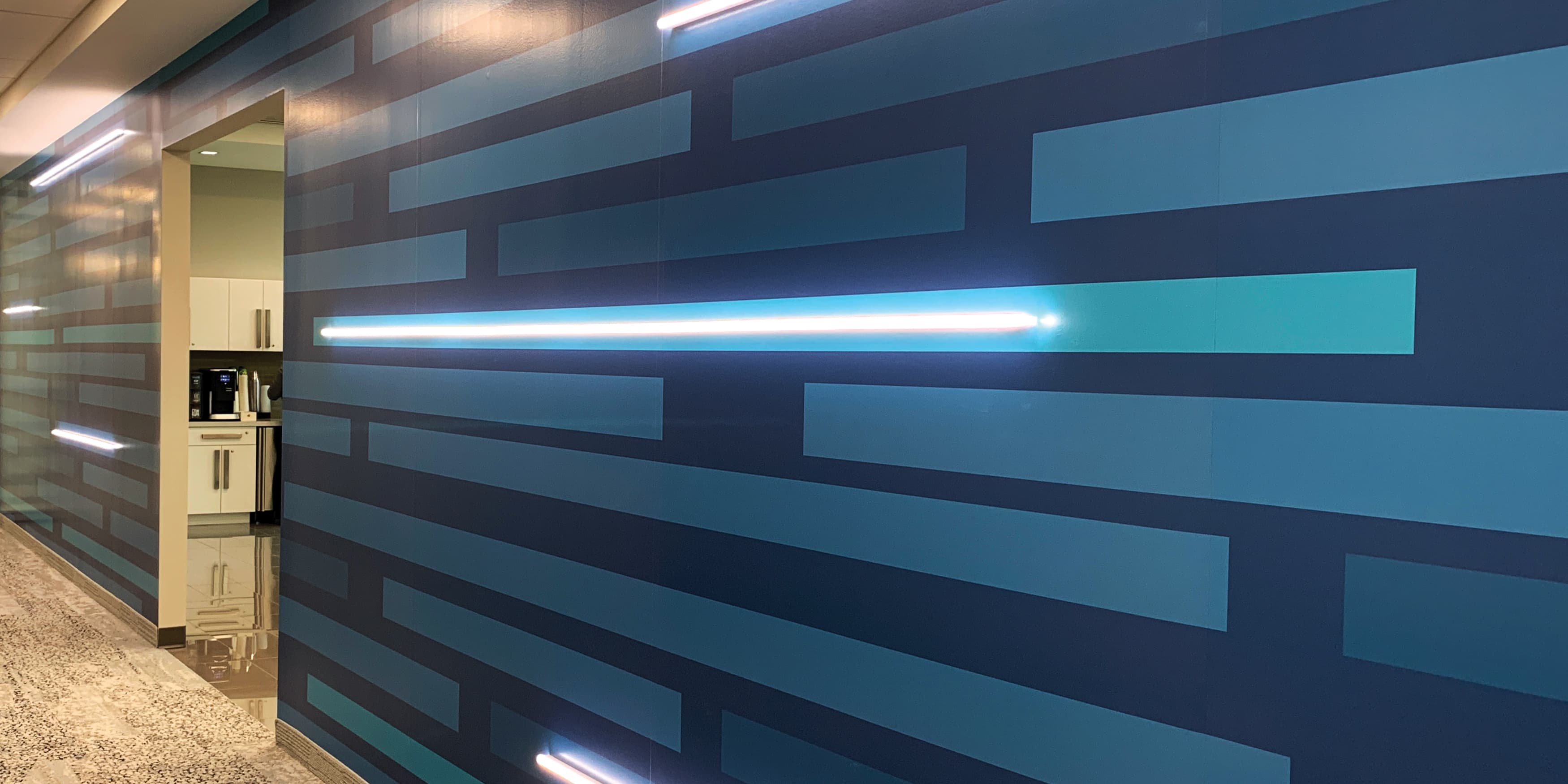 Speciality art mural by RSM Design for JMFE Headquarters consisting of blue dashed painted lines mixed with blue neon signage for office workplace design.