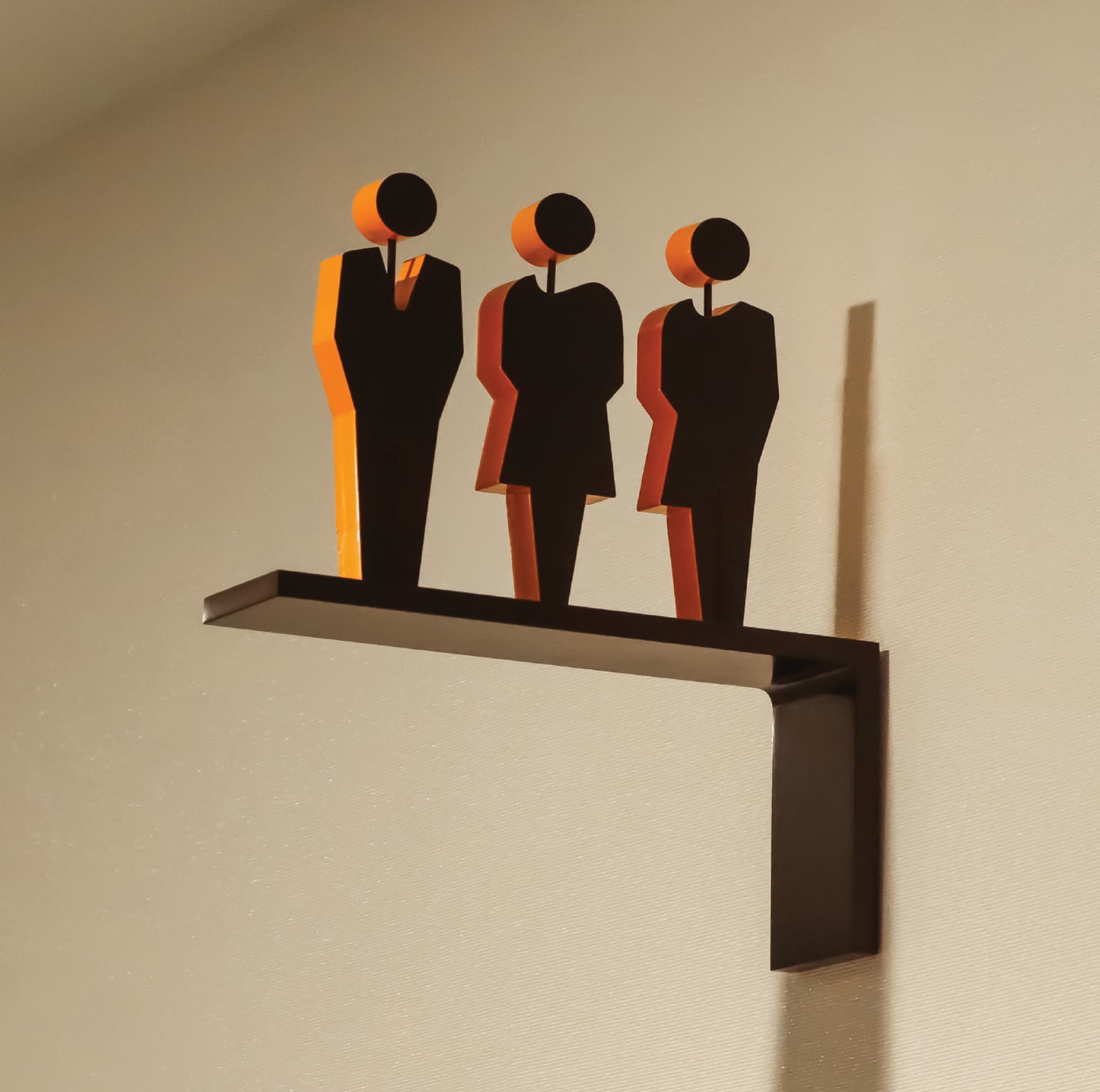 Dimensional restroom wayfinding icon with stylized figures mounted on wall, showcasing environmental graphic design, signage systems, and intuitive navigation for hospitality, retail, and mixed-use environments.