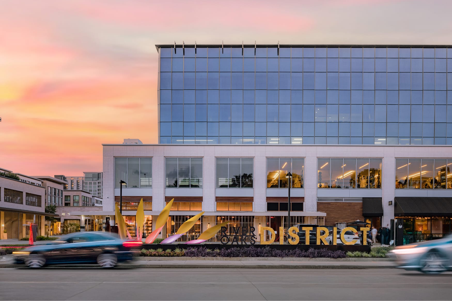 River Oaks District Houston illuminated monument sign with sculptural leaf art at dusk, environmental graphic design by RSM Design