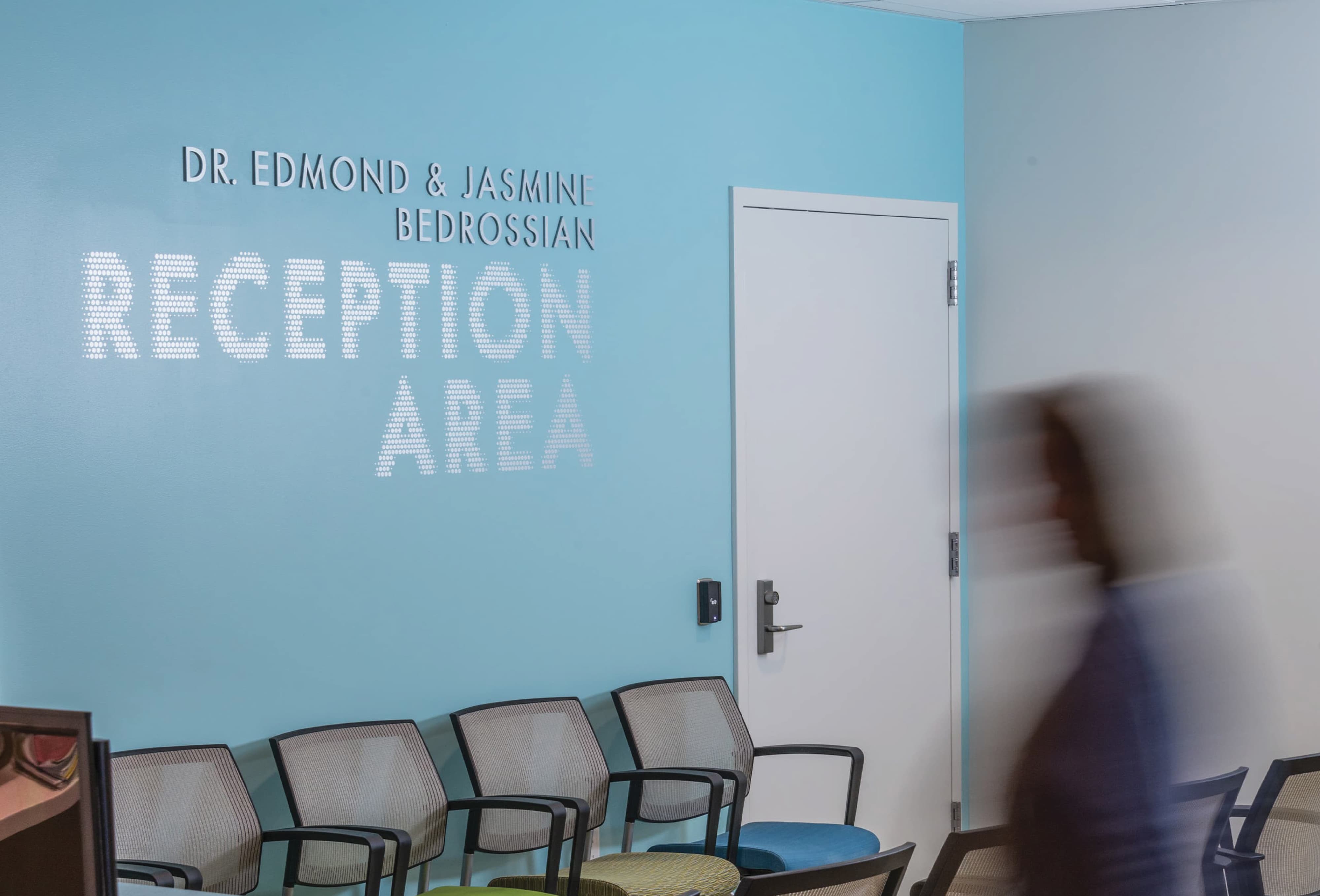 Donor recognition signage and dimensional "Reception Area" lettering on a light blue wall in a healthcare waiting room, combining wayfinding and signage design with experiential graphics by RSM Design.