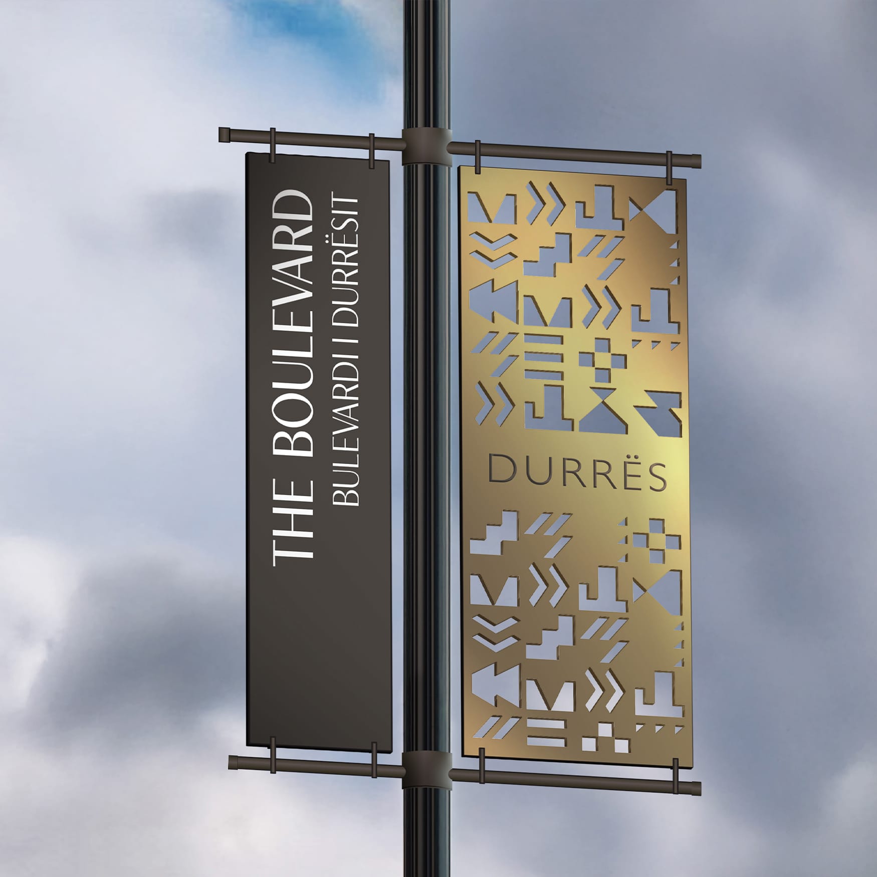 Decorative boulevard banner featuring the Durrës, Albania identity, with a bronze geometric pattern and black vertical sign mounted to a dark metal street pole.