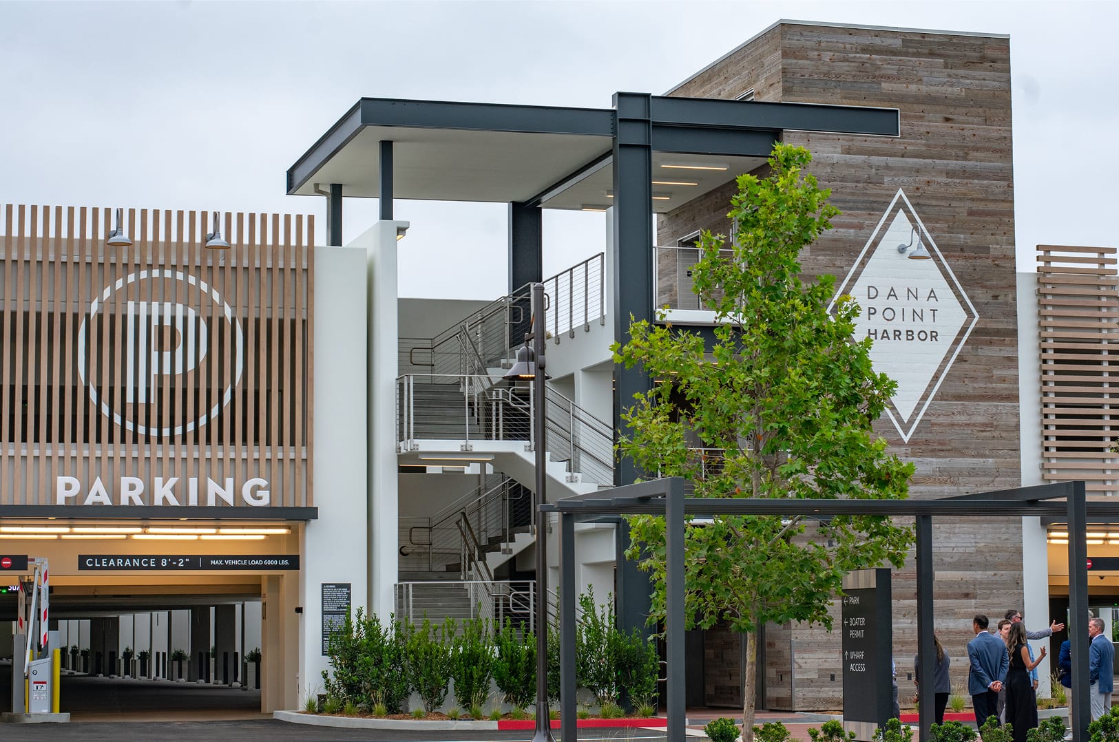 Dana Point Harbor parking structure and identity signage with dimensional parking graphic and diamond logo mark on reclaimed wood facade — wayfinding and environmental graphic design by RSM Design