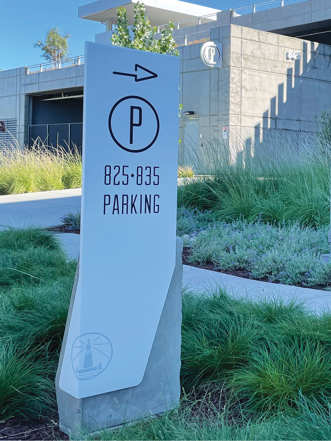 Exterior parking wayfinding monument sign with lighthouse icon directing visitors to 825-835 parking structure at San Carlos mixed-use development, environmental graphic design by RSM Design