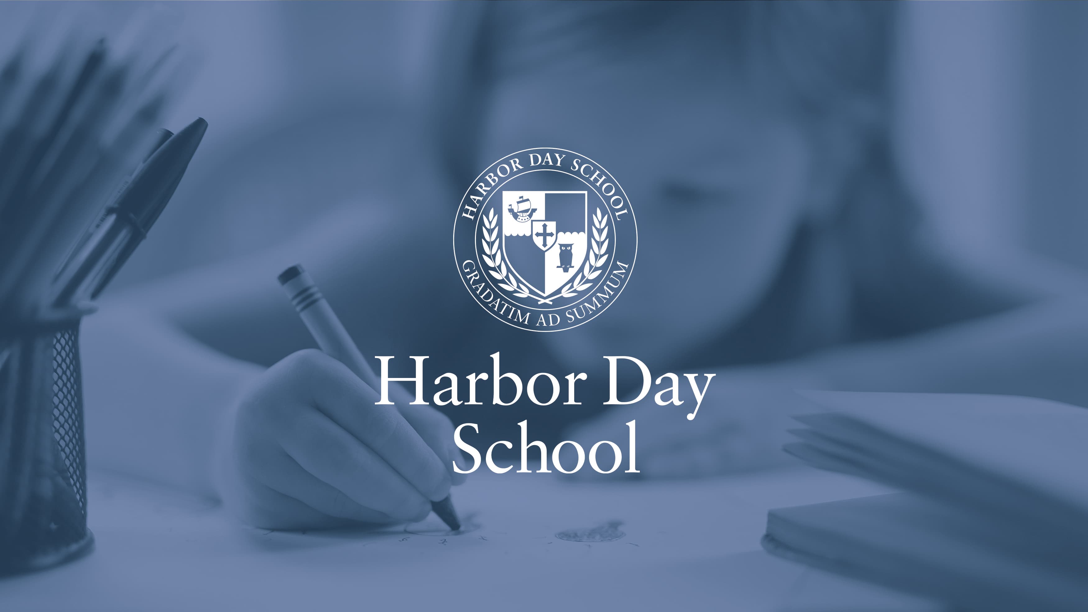 Harbor Day logo on an image of a young girl drawing at school.