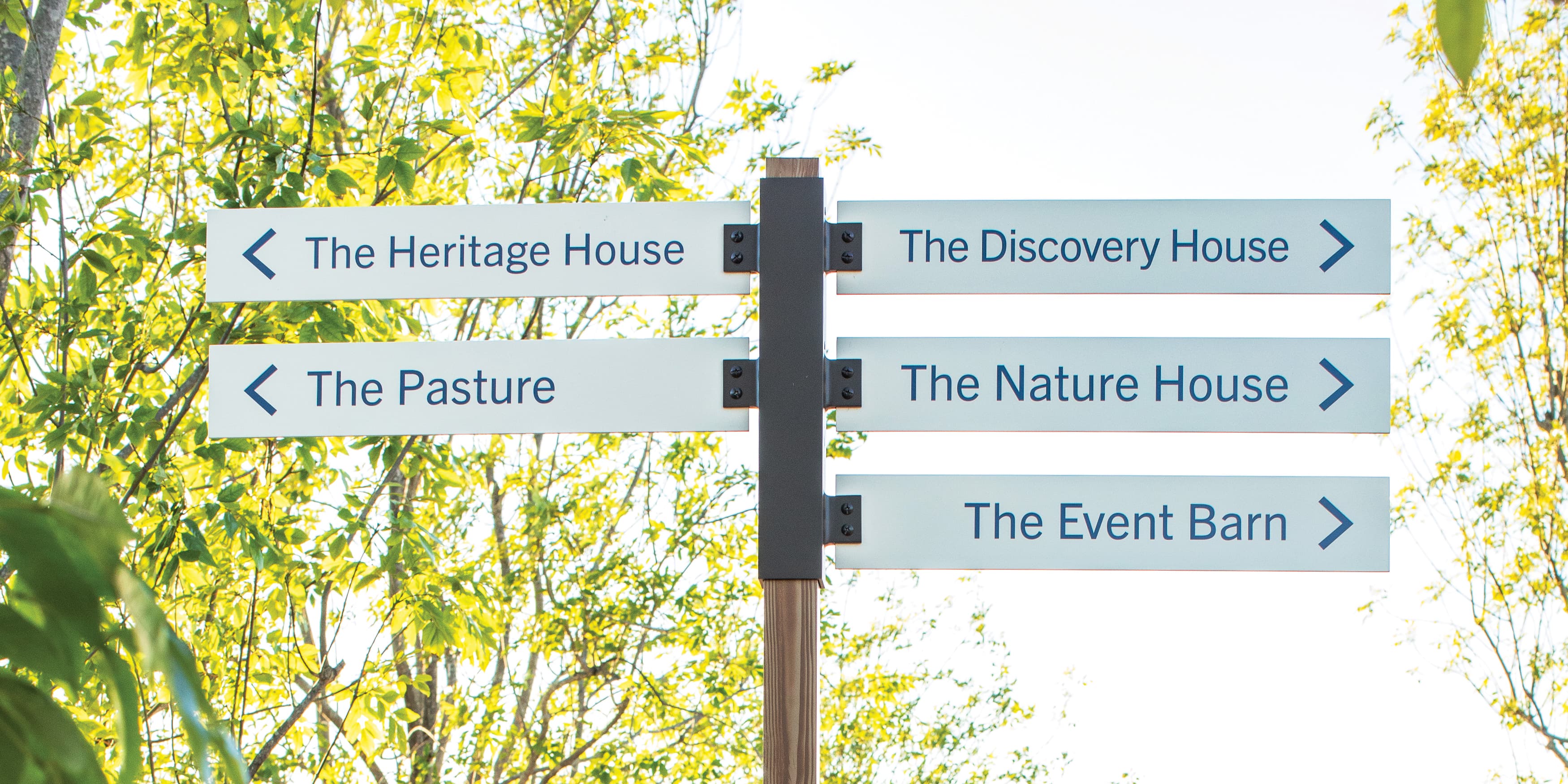 Close up detail shot of directional sign in clean, modern style with minimal typography for Ranch Camp by RSM Design. 