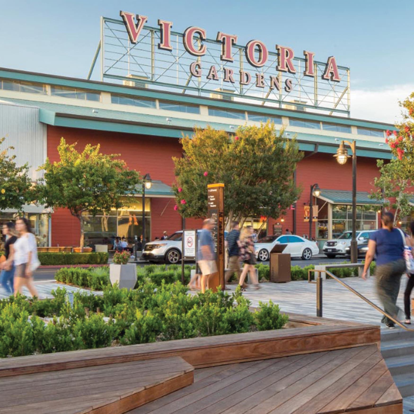 Outdoor market at Victoria Gardens with identity signage in background