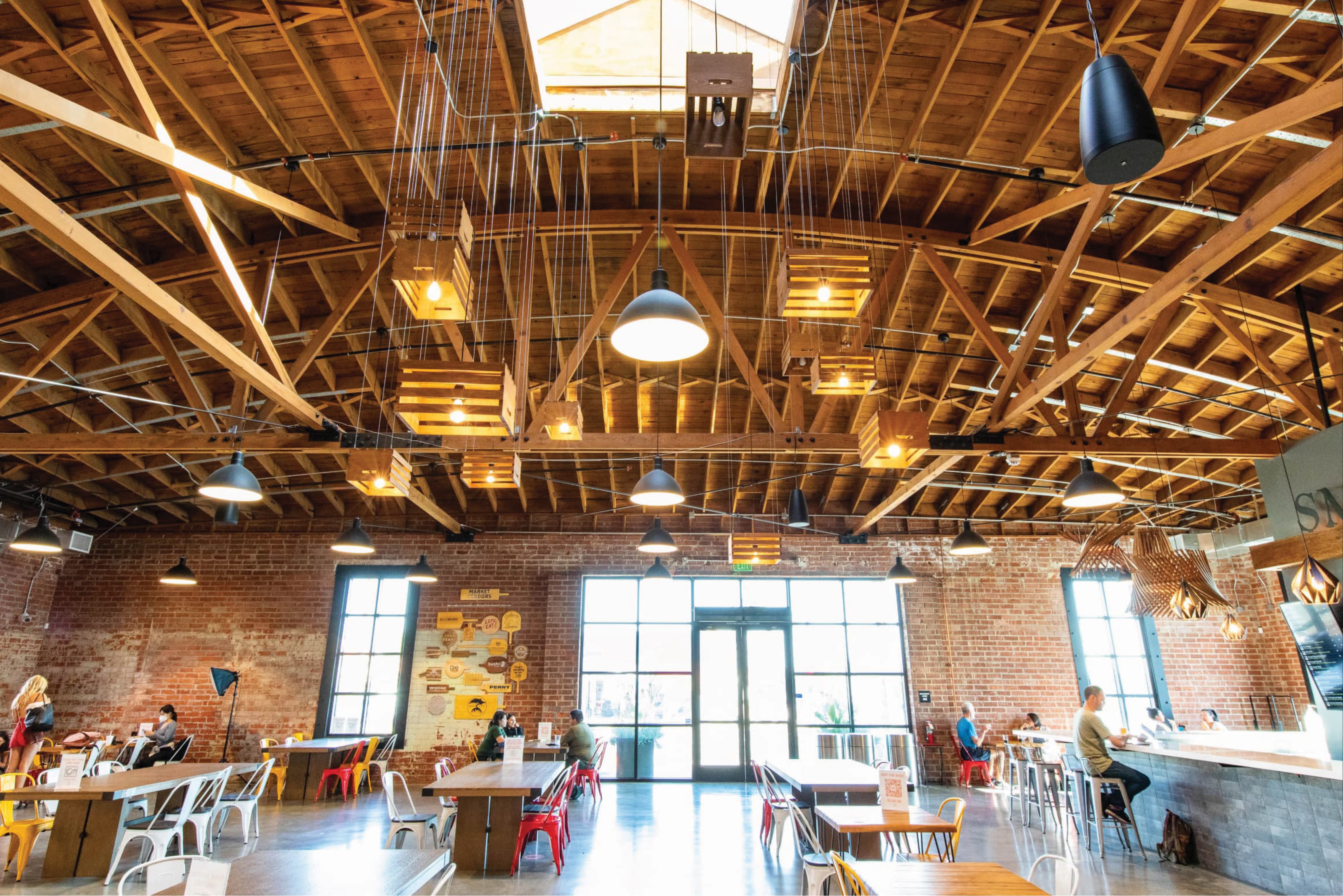 Interior of a public market food hall featuring branded environmental graphics, wayfinding, and placemaking design within a retail and hospitality mixed-use destination, enhancing the guest experience through RSM Design’s experiential design approach