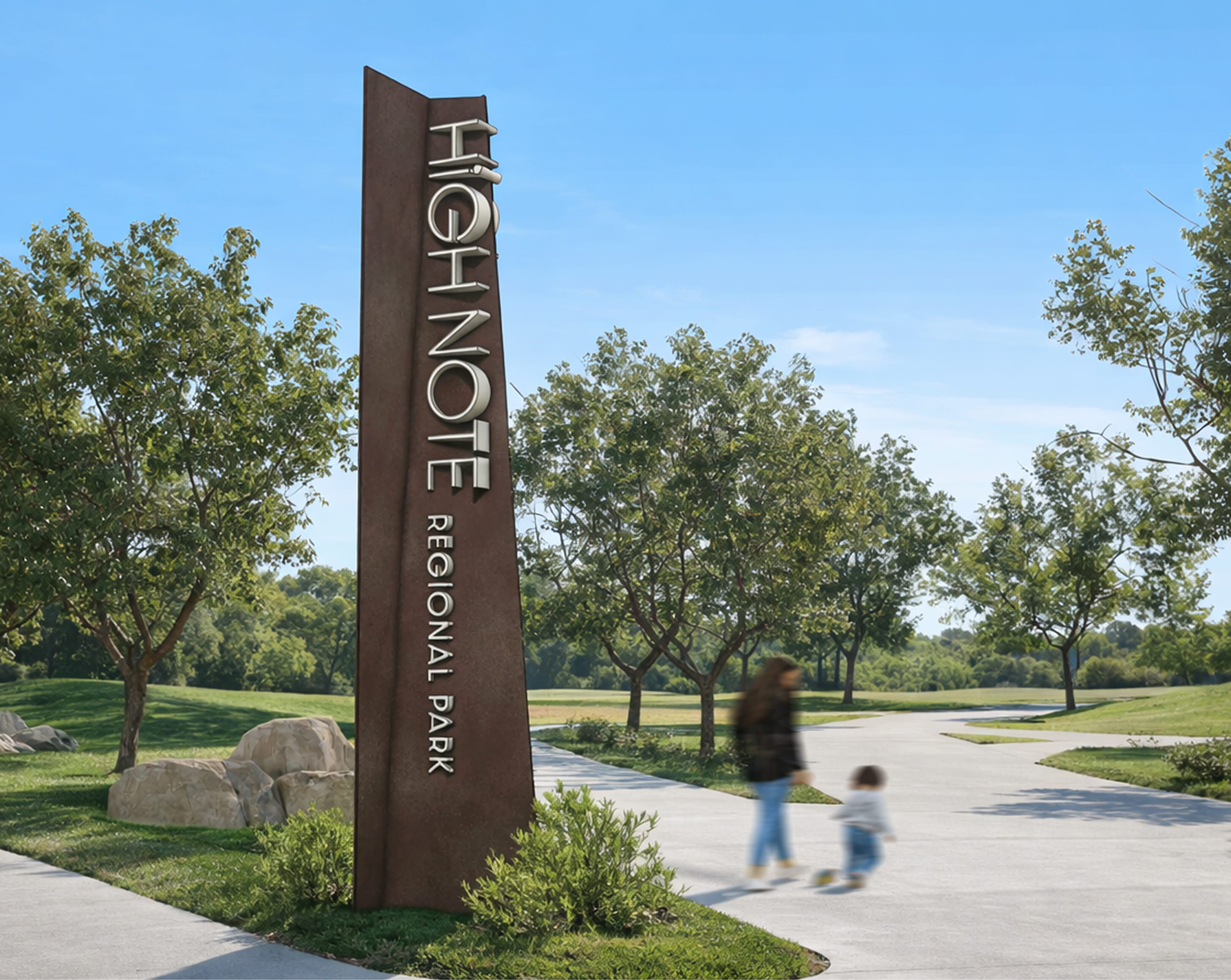 Tall angled corten steel monument sign reading "HighNote Regional Park" vertically, set among boulders and shrubs along a park path with an adult and child walking nearby — environmental graphic design and signage by RSM Design.