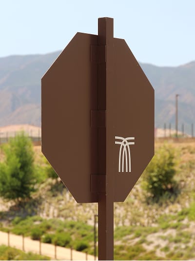 Octagonal stop sign etched with the Terramor logo mark against a hillside backdrop - environmental graphic design by RSM Design