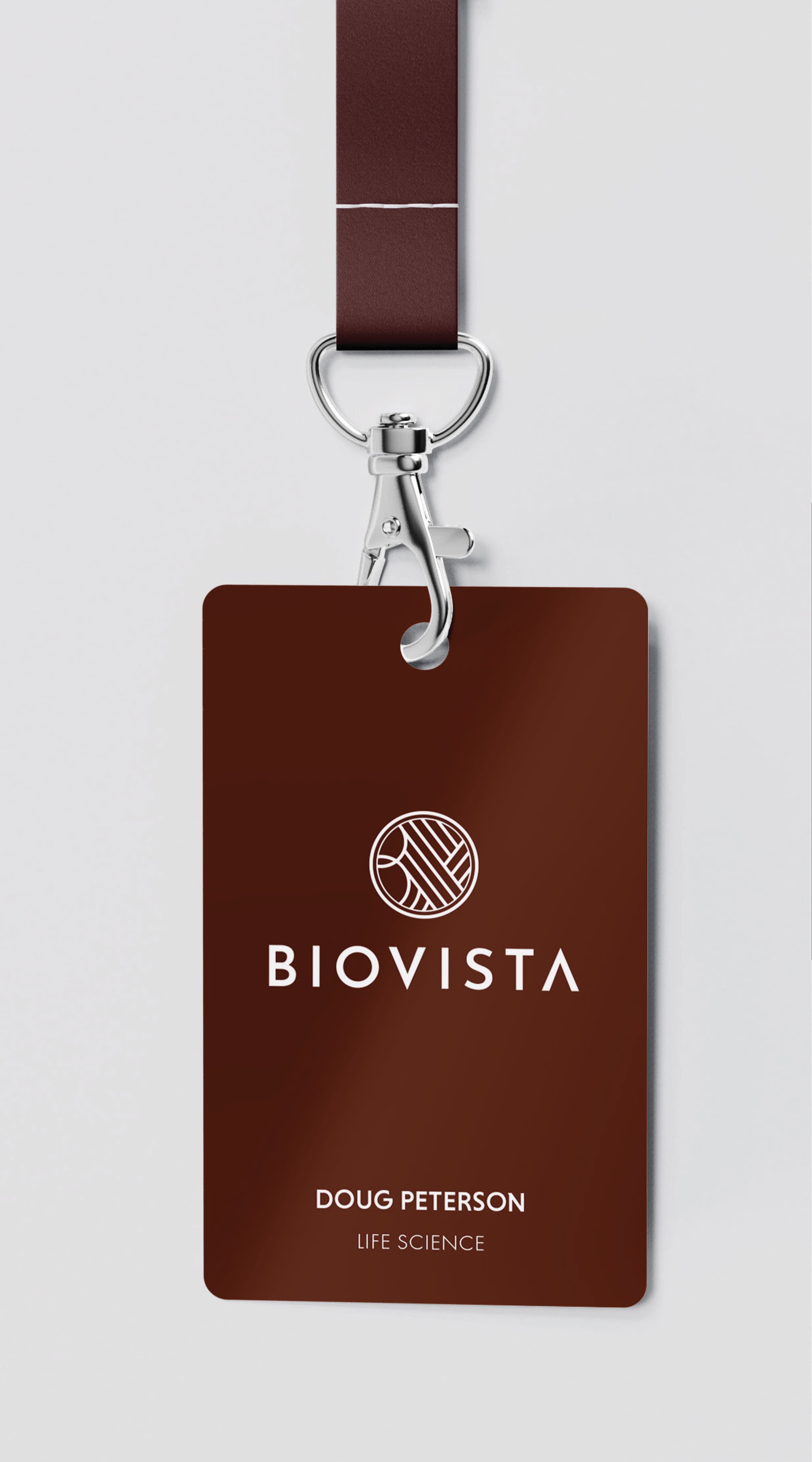 Rendering of a dark brown ID badge on a matching lanyard with a metal clip, displaying the white Biovista logo and wordmark, with 'Doug Peterson, Life Science' printed below.