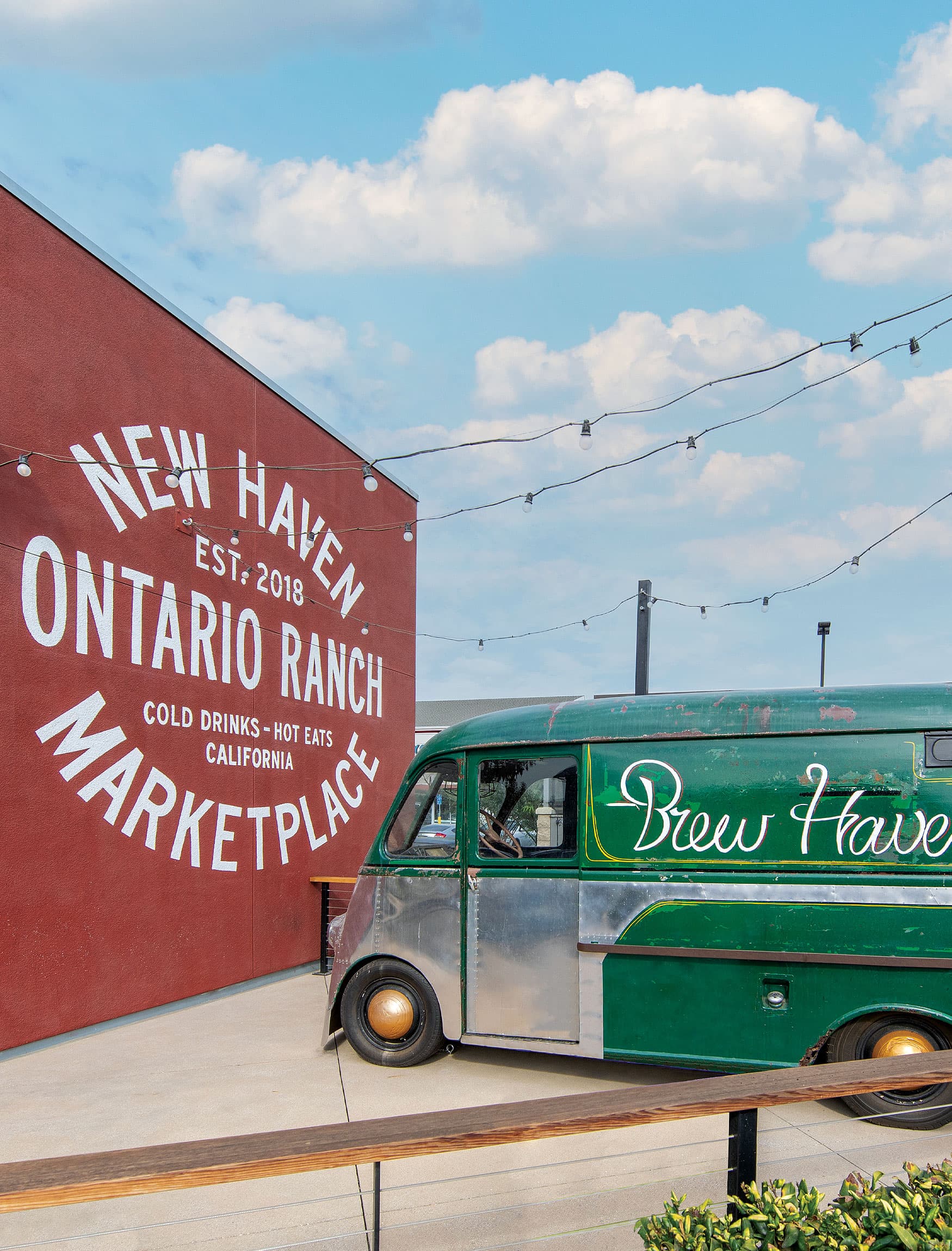Painted mural for side of the building in New Haven Marketplace in Ontario, California. White lettering against red painted wall. Green truck with Brew Haven cursive font.