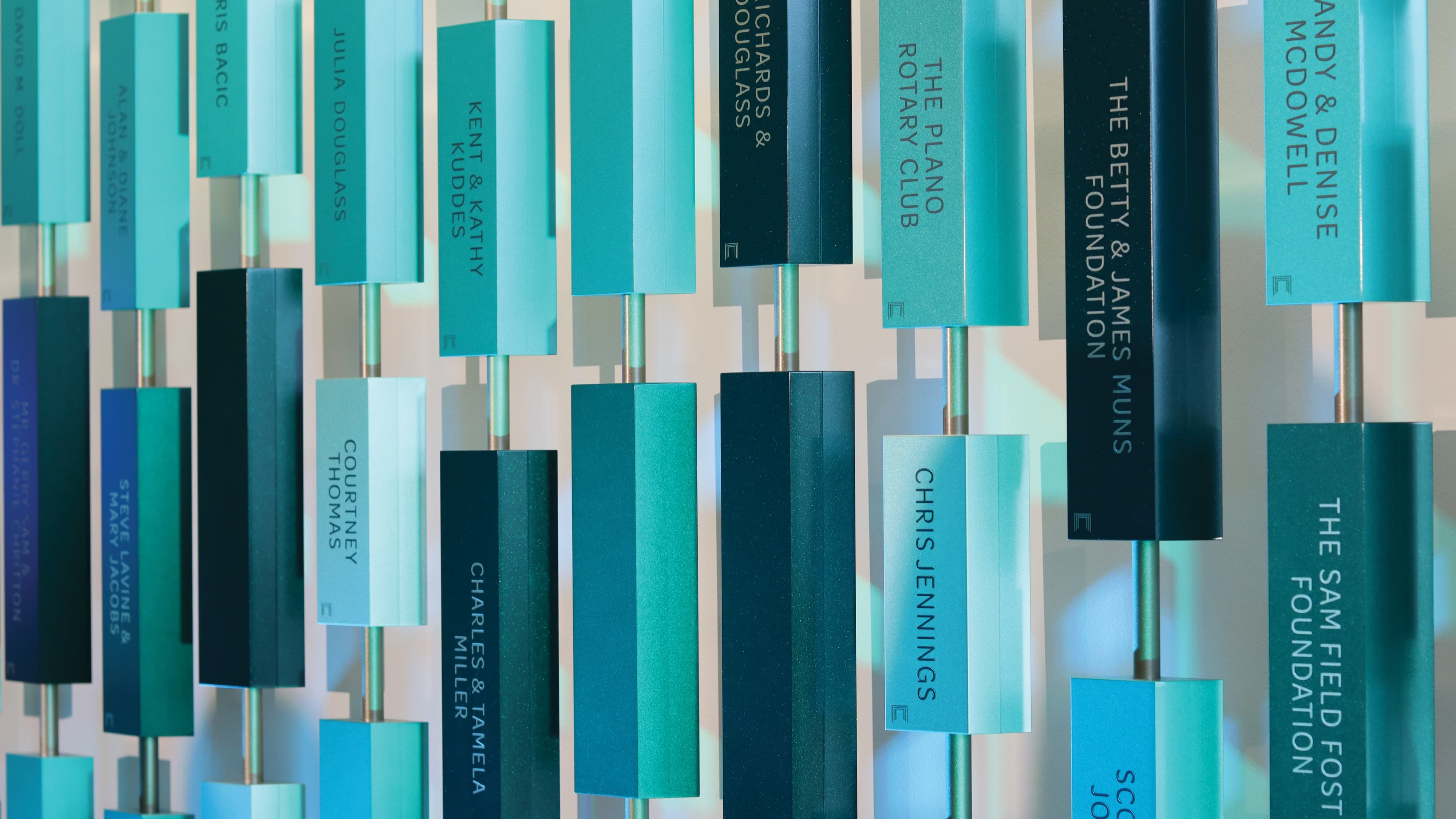 Dimensional donor recognition installation featuring layered name plaques and sculptural elements, illustrating environmental graphic design, experiential storytelling, and placemaking within a higher education and healthcare environment.