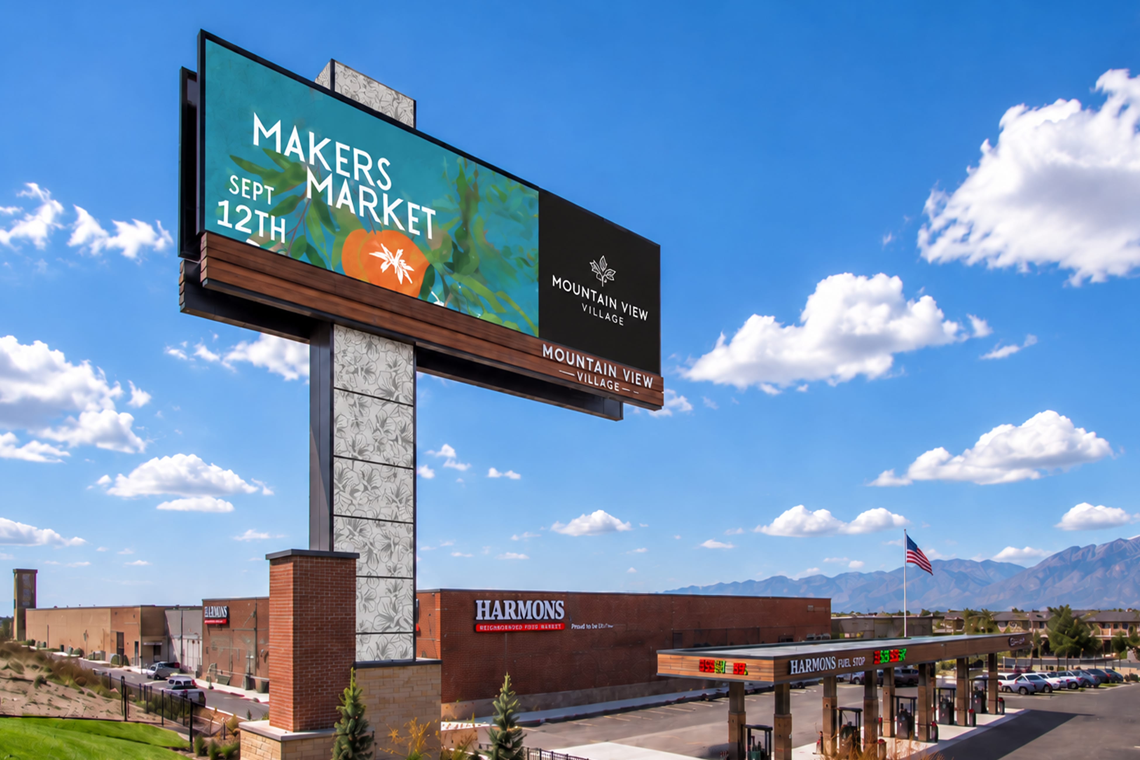 Elevated digital billboard promoting a "Makers Market" event alongside the Mountain View Village logo, rising above a Harmons grocery store and fuel station in Riverton, Utah — wayfinding and environmental graphic design by RSM Design.